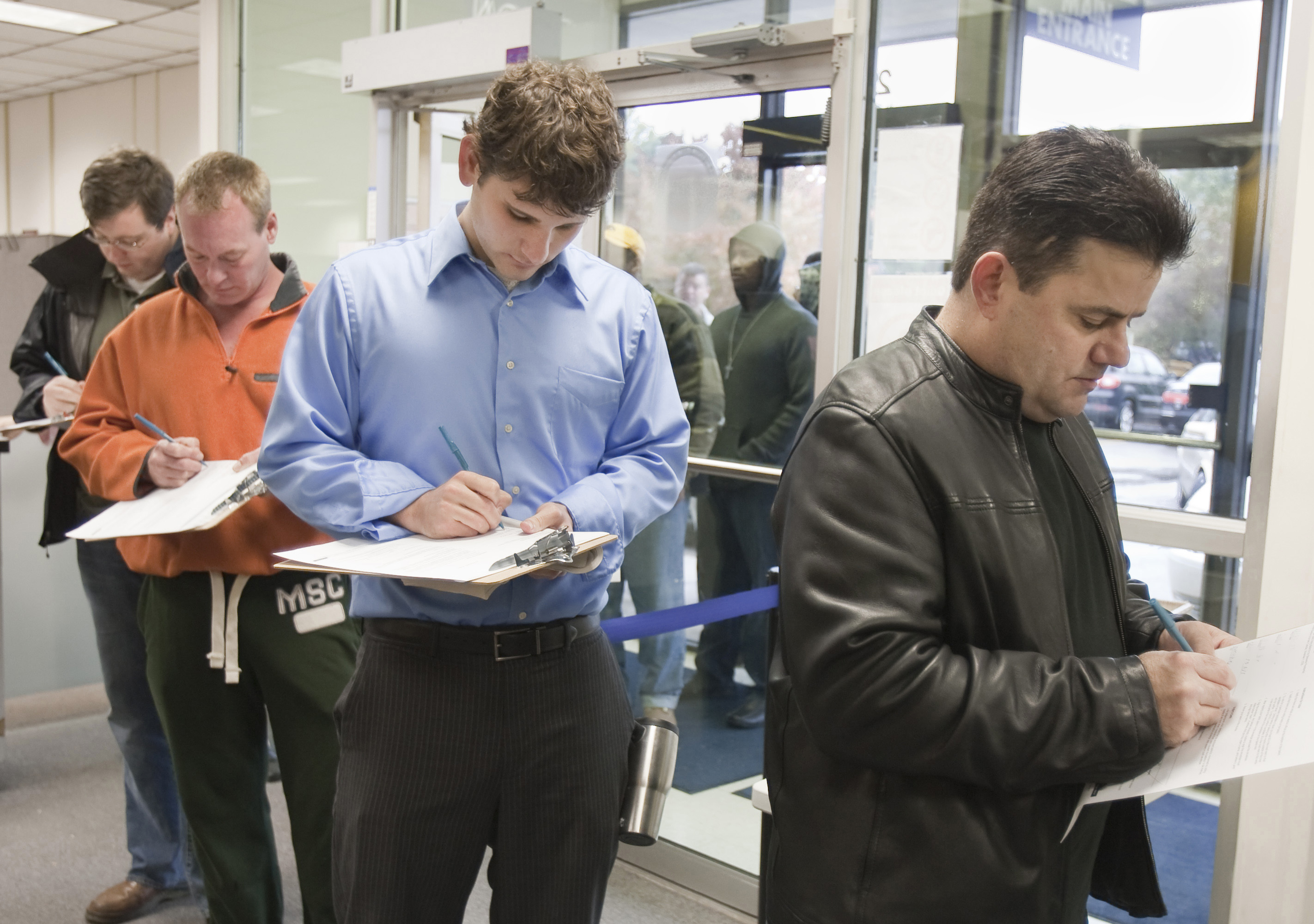 University of Nebraska Medical Center student Dan Lercher (center) fills a form while standing in line to vote early, at the Douglas County Election Commission office, in Omaha, Neb., Wednesday, Oct. 22, 2008.<br />(Nati Harnik / AP Photo)
