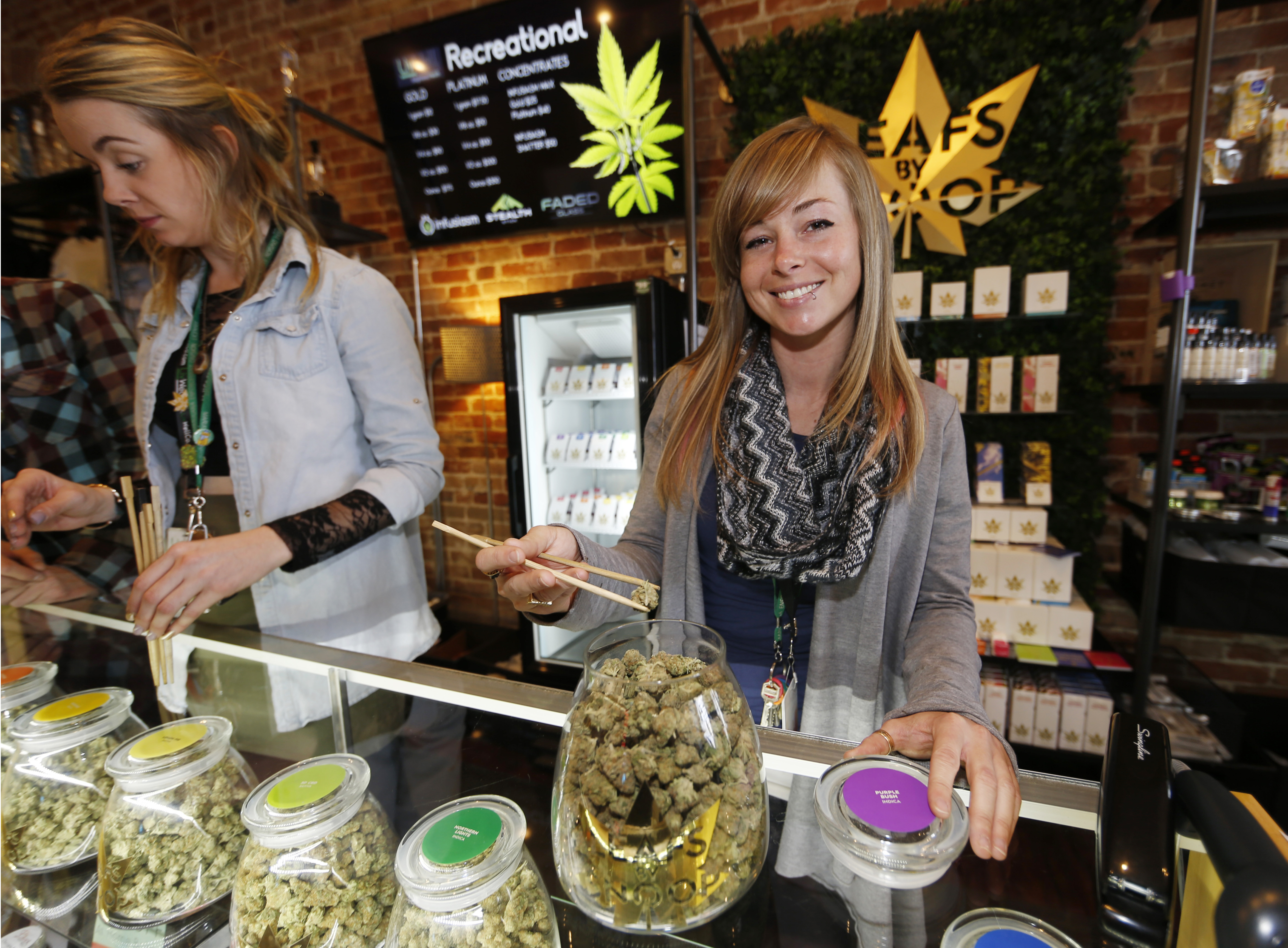 Friday, Dec. 18, 2015, LivWell store manager Carlyssa Scanlon shows off some of the products available in the marijuana line marketed by rapper Snoop Dogg in one of the marijuana chain&#039;s outlets south of downtown Denver. LivWell grows the Snoop pot alongside many other strains on its menu.<br />(David Zalubowski / AP Photo)