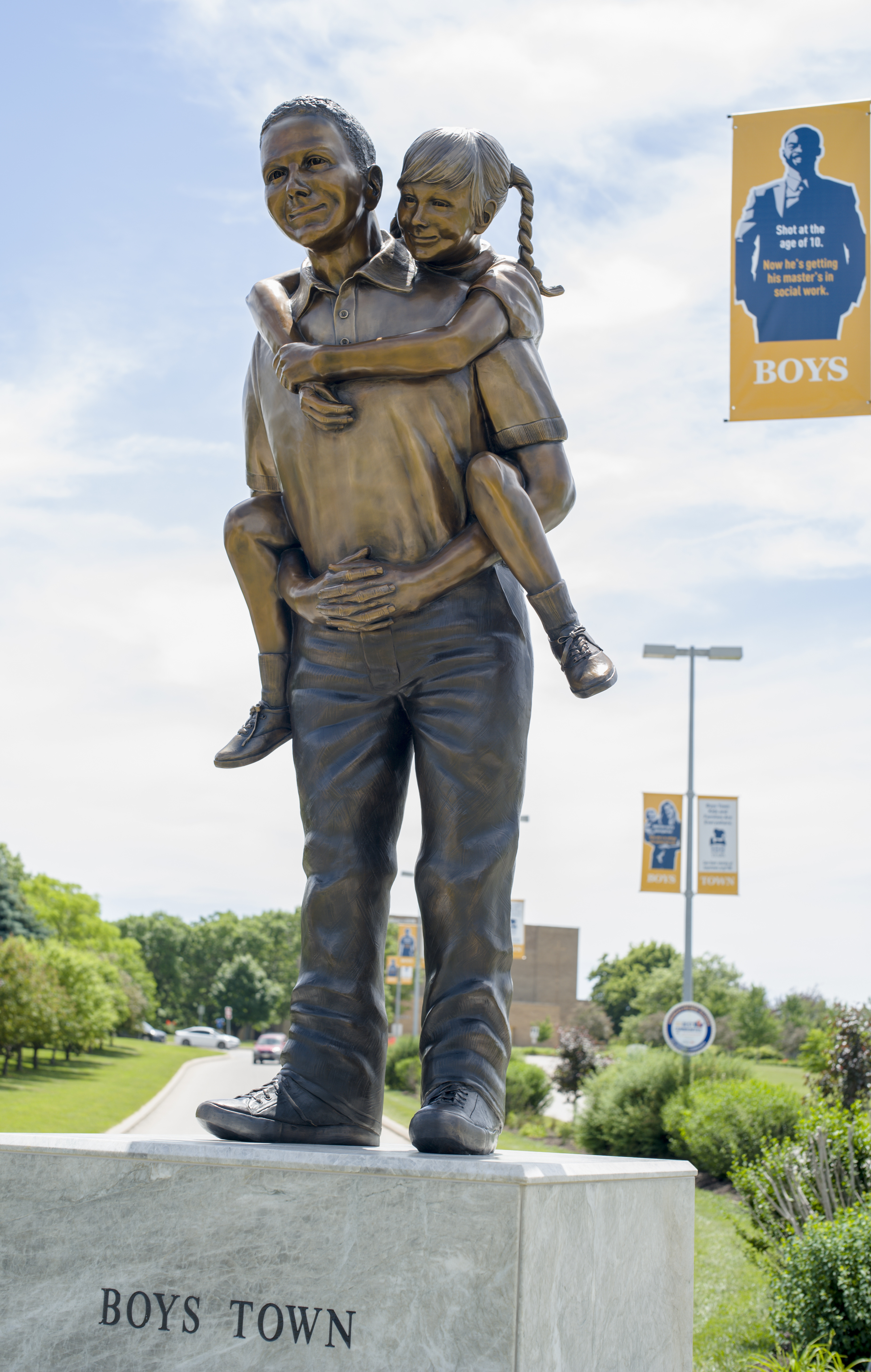 The Boys Town statue at the entrance to Boys Town, Neb. This statue replaced the “Two Brothers” statue that is currently displayed elsewhere in Boys Town, and shows that hardship isn’t exclusive to one race or gender. (Nati Harnik / AP Photo)
