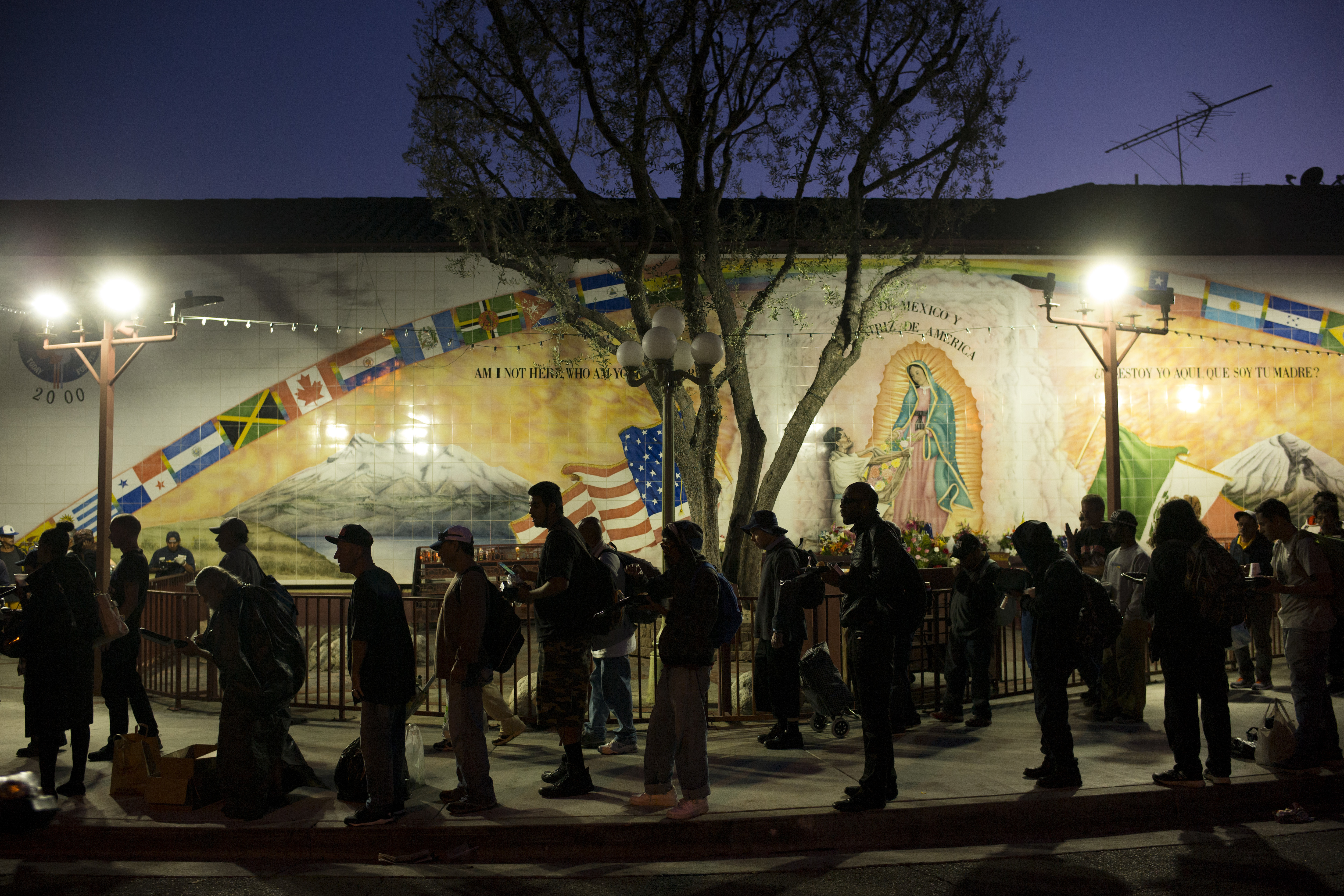 Homeless people wait in line for a meal served by a community organization outside Our Lady Queen of Angels Catholic Church Thursday, Sept. 21, 2017, in Los Angeles. A homeless crisis of unprecedented proportions is rocking the West Coast, and its victims are being left behind by the very things that mark the region&#039;s success: soaring housing costs, rock-bottom vacancy rates and a roaring economy that waits for no one.<br />(Jae C. Hong / AP Photo)