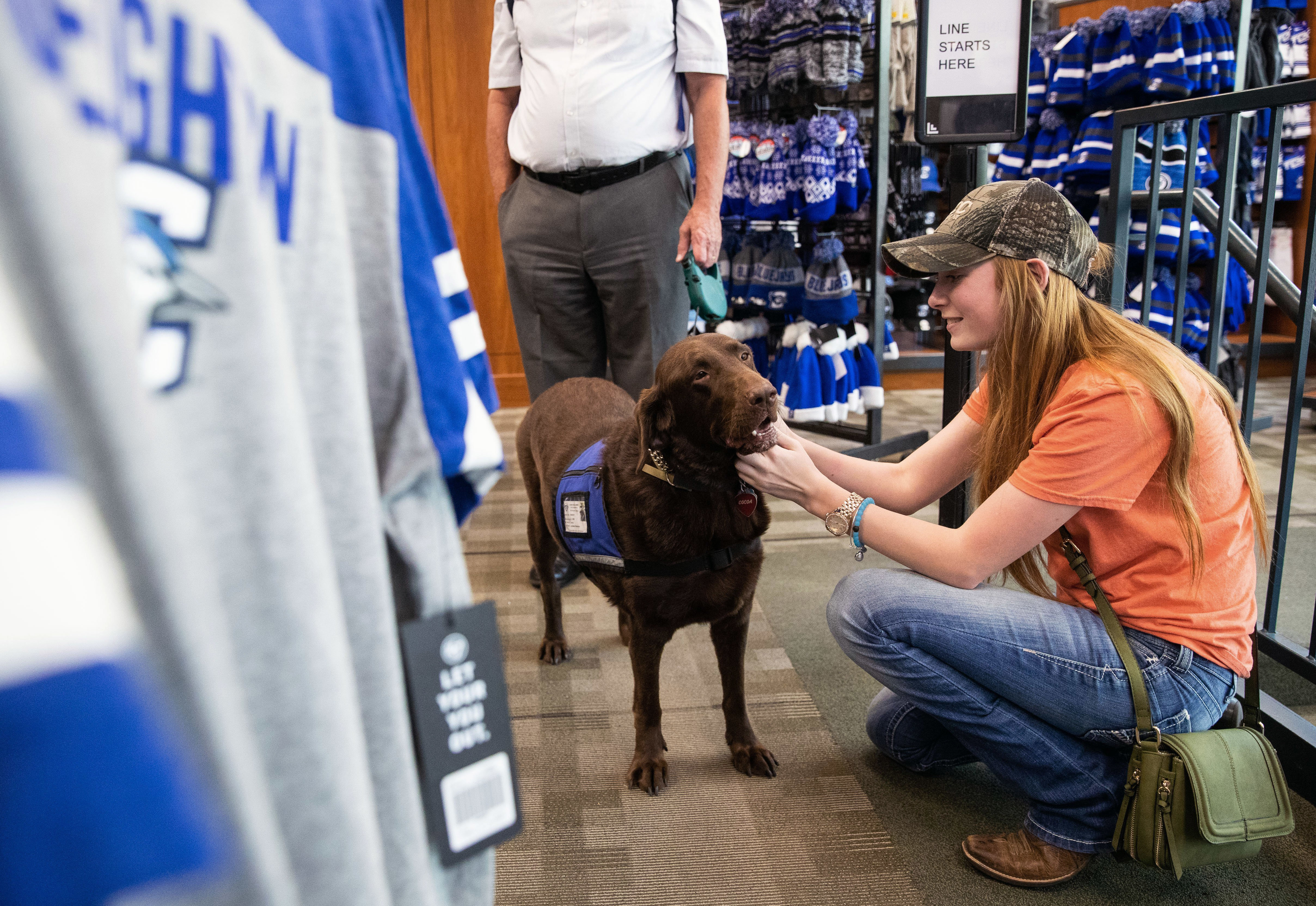 In this Tuesday, July 24, 2018 photo, Saige Steffensmeier pets Cocoa on the campus of Creighton University in Omaha, Neb. Cocoa serves as a therapy dog for the Center for Health and Counseling at Creighton University.<br /> (Brendan Sullivan / Omaha World-Herald via AP)