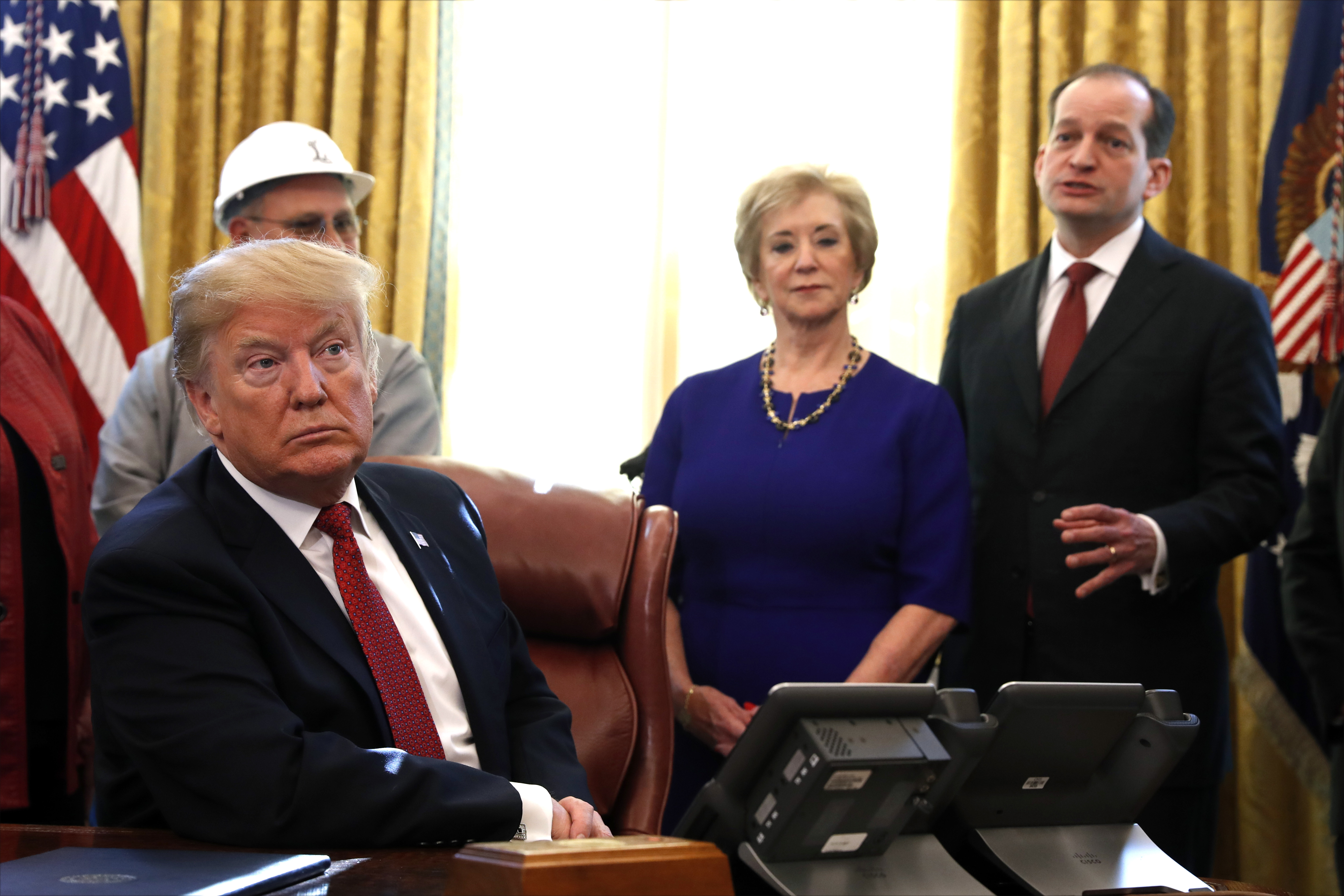 President Donald Trump listens as Labor Secretary Alex Acosta (right) speaks during a meeting with American manufacturers in the Oval Office of the White House, Thursday, Jan. 31, 2019, in Washington. Trump was signing an executive order pushing those who receive federal funds to &quot;buy American.&quot; Small Business Administrator Linda McMahon is second from right.<br />(Jacquelyn Martin / AP Photo)