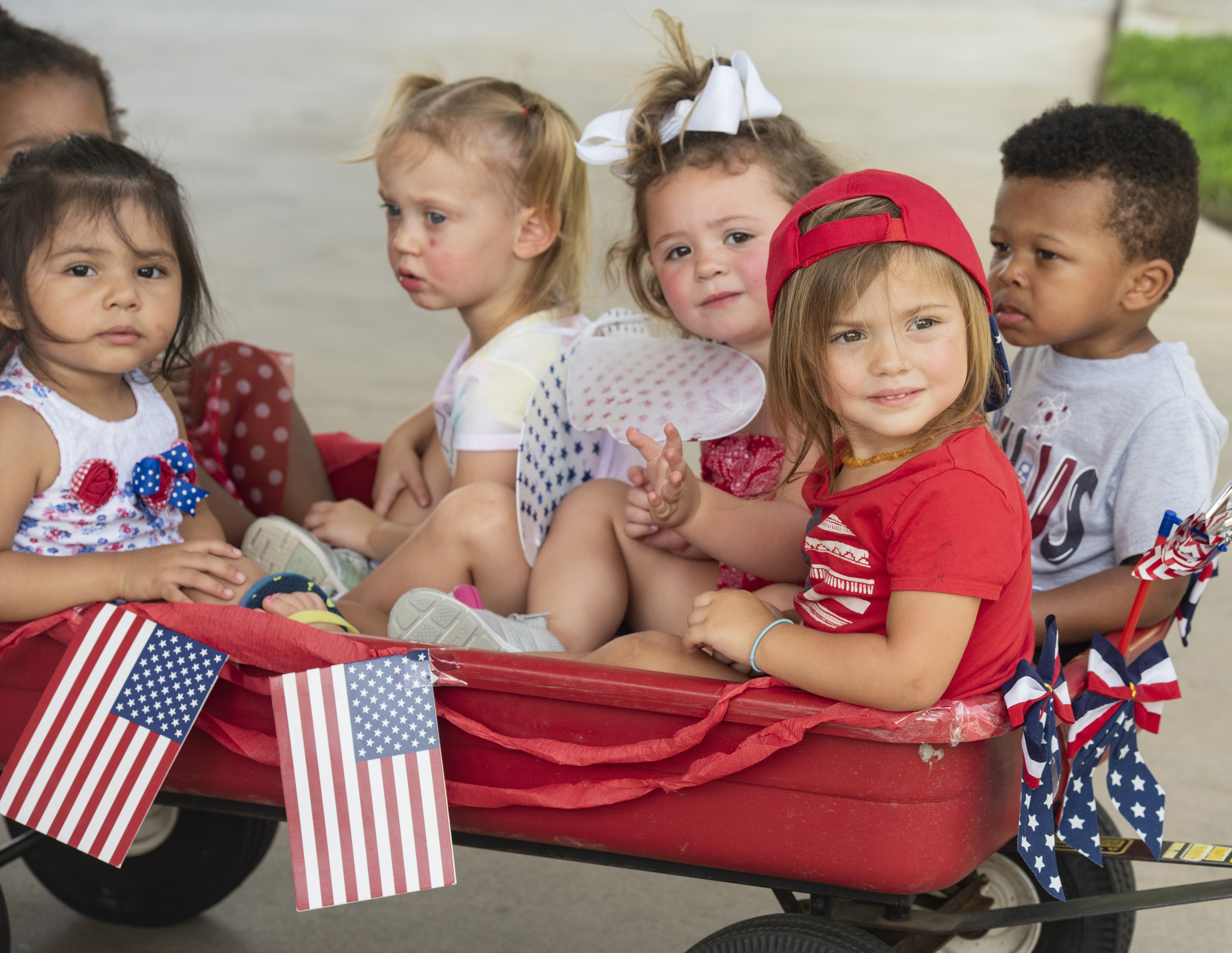 Children from Stepping Stone School in Tyler, Texas, ride together in a wagon pulled by their teacher for their annual parking lot Fourth of July parade on Friday, July 3, 2020.<br />(Sarah A. Miller / Tyler Morning Telegraph via AP)