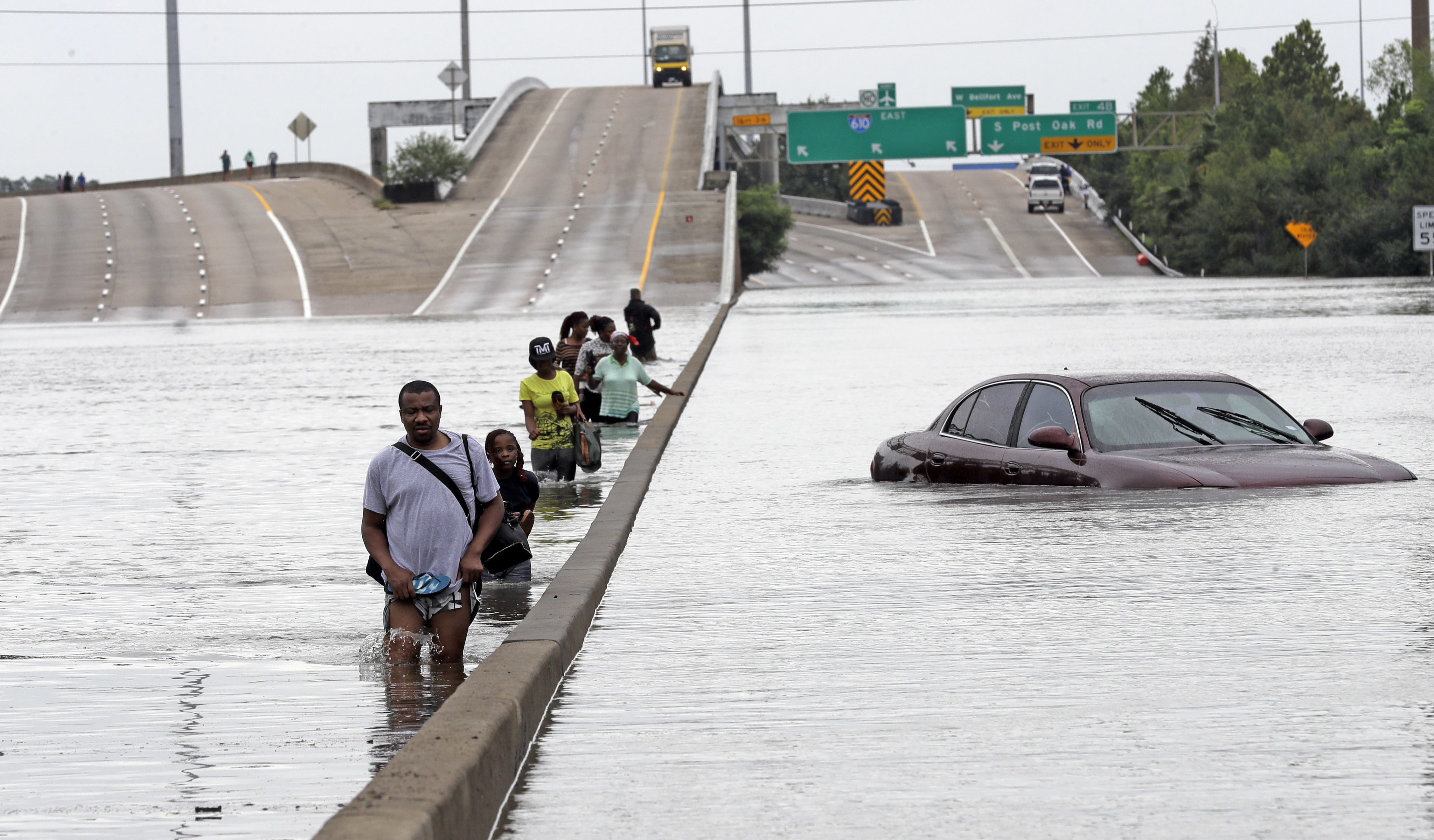 Evacuees wade through floodwaters from Tropical Storm Harvey on a section of Interstate 610 in Houston. Houston area officials expressed shock and anger on Friday, May 21, 2021, after learning that their communities, which suffered the brunt of damage from Hurricane Harvey, would be getting a fraction of $1 billion that Texas is awarding as part of an initial distribution of federal funding given to the state for flood mitigation.<br />(David J. Phillip / AP Photo)