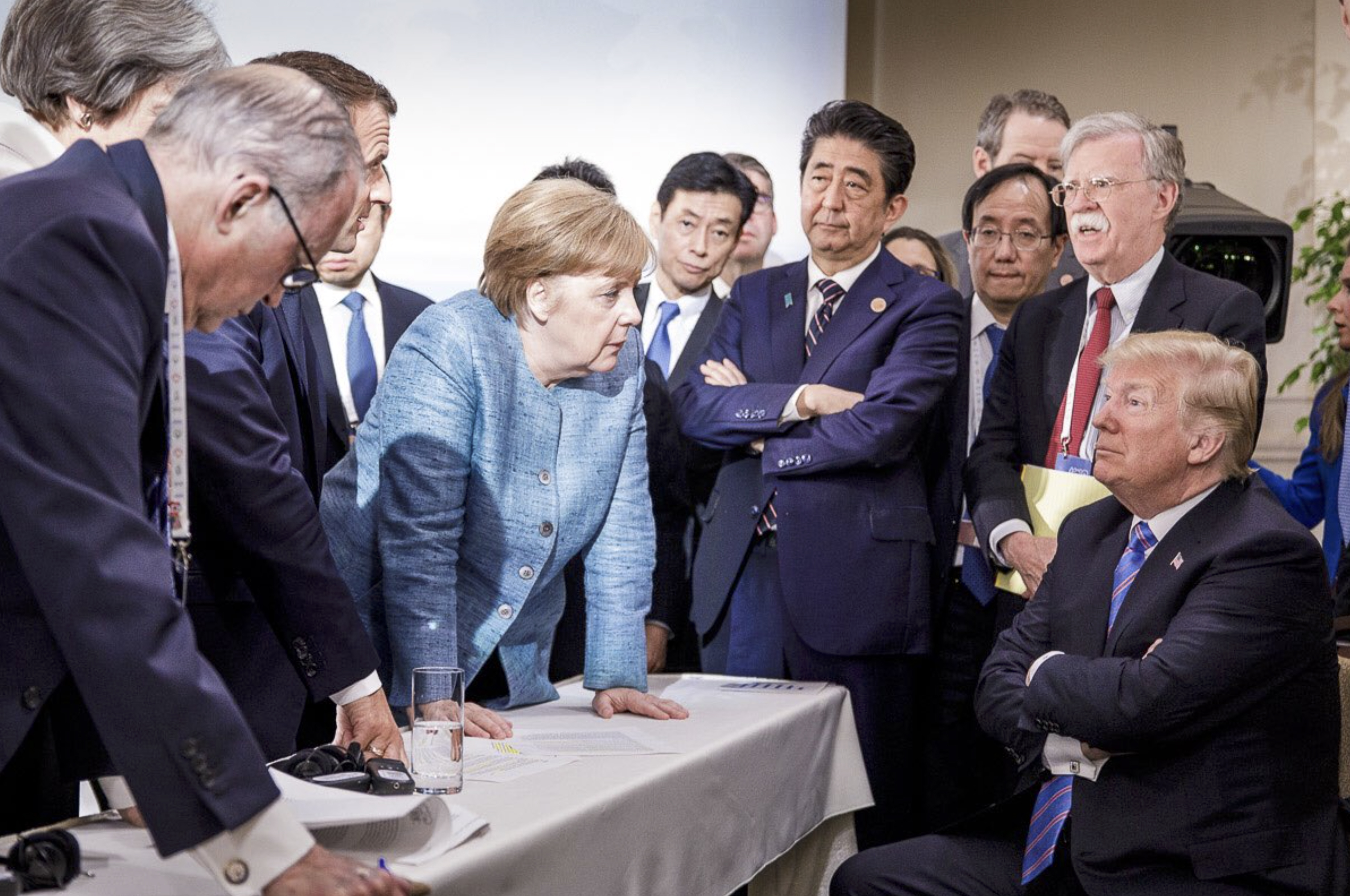 In this photo made available by the German Federal Government, German Chancellor Angela Merkel (center) speaks with U.S. President Donald Trump (seated at right) during the G7 Leaders Summit in La Malbaie, Quebec, Canada, June 9, 2018.<br />(Jesco Denzel / German Federal Government via AP)