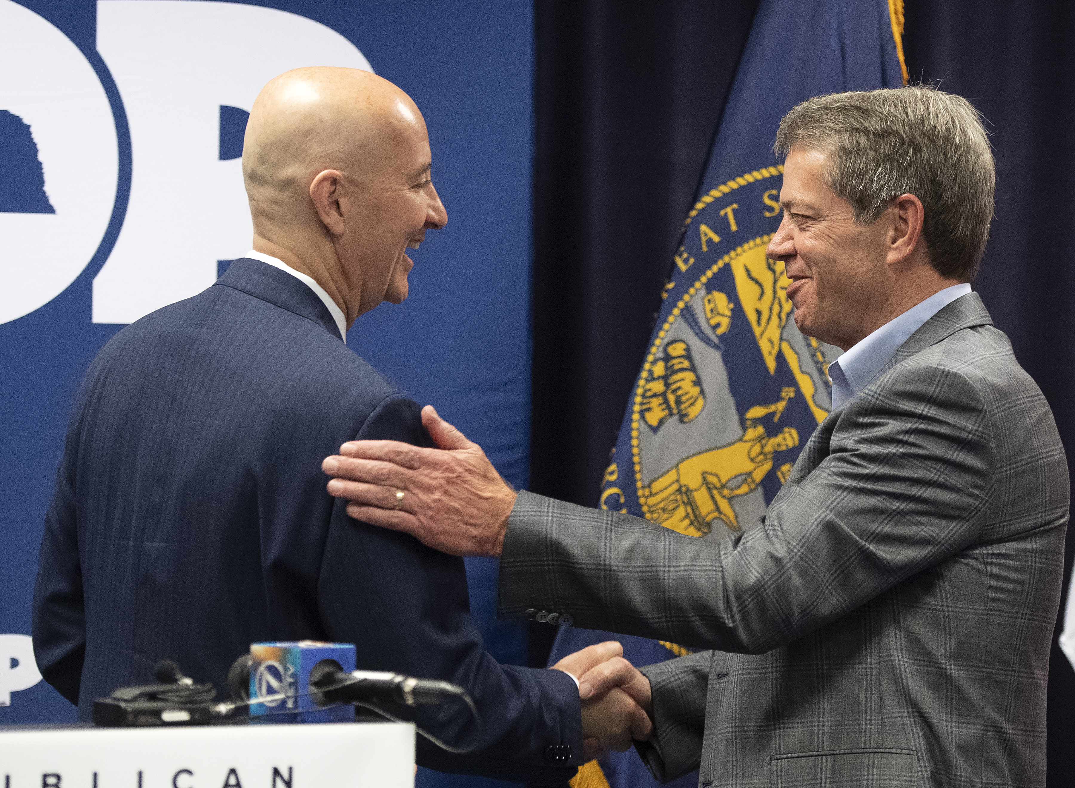 Gov. Pete Ricketts, left, shakes hands with Gov. Elect Jim Pillen, during the Nebraska Republican Party general election kickoff at the Republican state headquarters, Wednesday, May 11, 2022, in Lincoln, Neb. (Gwyneth Roberts / Lincoln Journal Star via AP Photo)