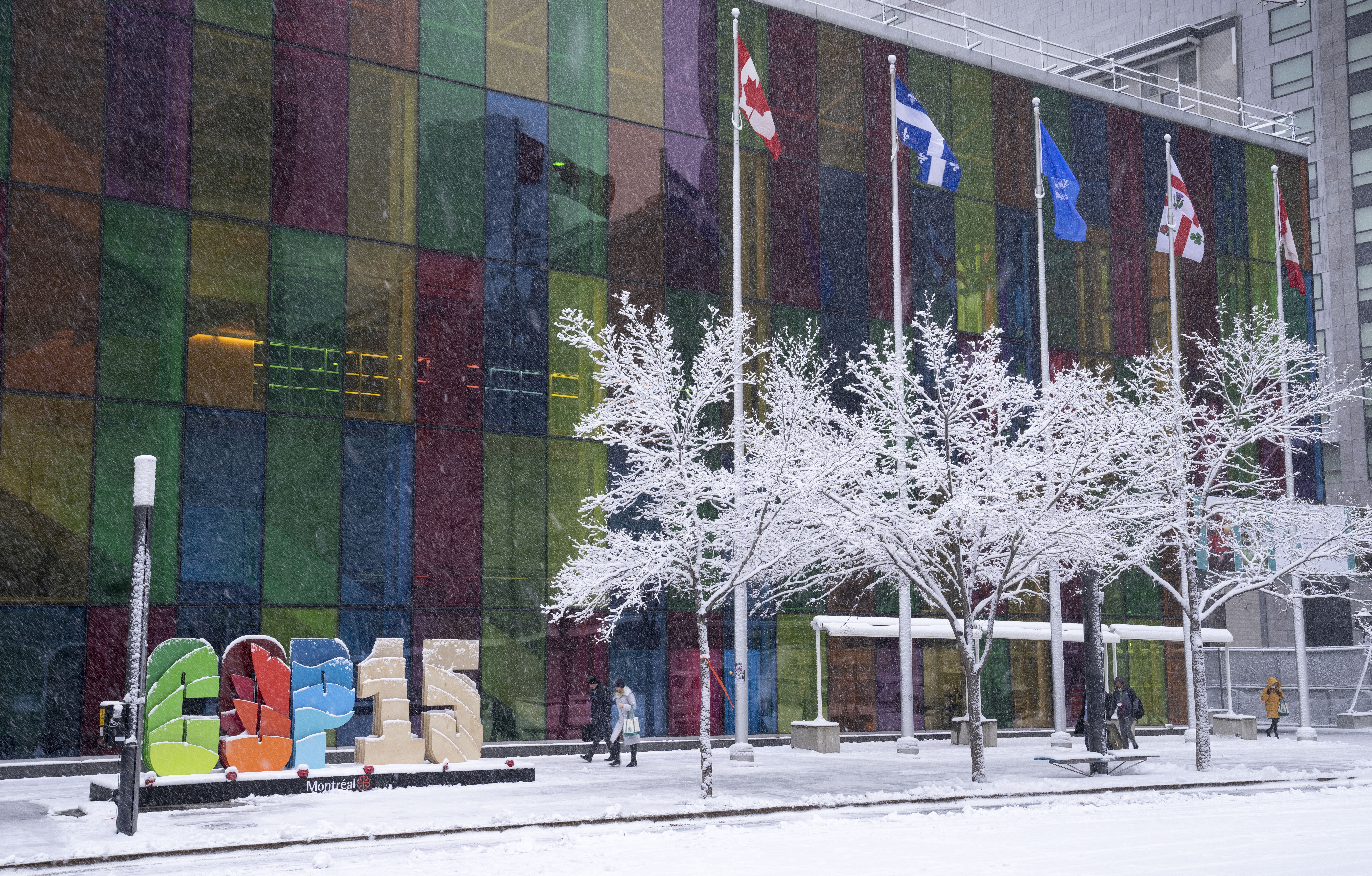 Delegates arrive at the convention center at the COP15 UN conference on biodiversity during a snowfall in Montreal, Friday, Dec. 16, 2022. After a historic biodiversity agreement was reached, countries now face pressure to deliver on the promises. The most significant part of the global biodiversity framework is a commitment to protect 30% of land and water considered important for biodiversity by 2030. (Paul Chiasson / The Canadian Press via AP Photo)