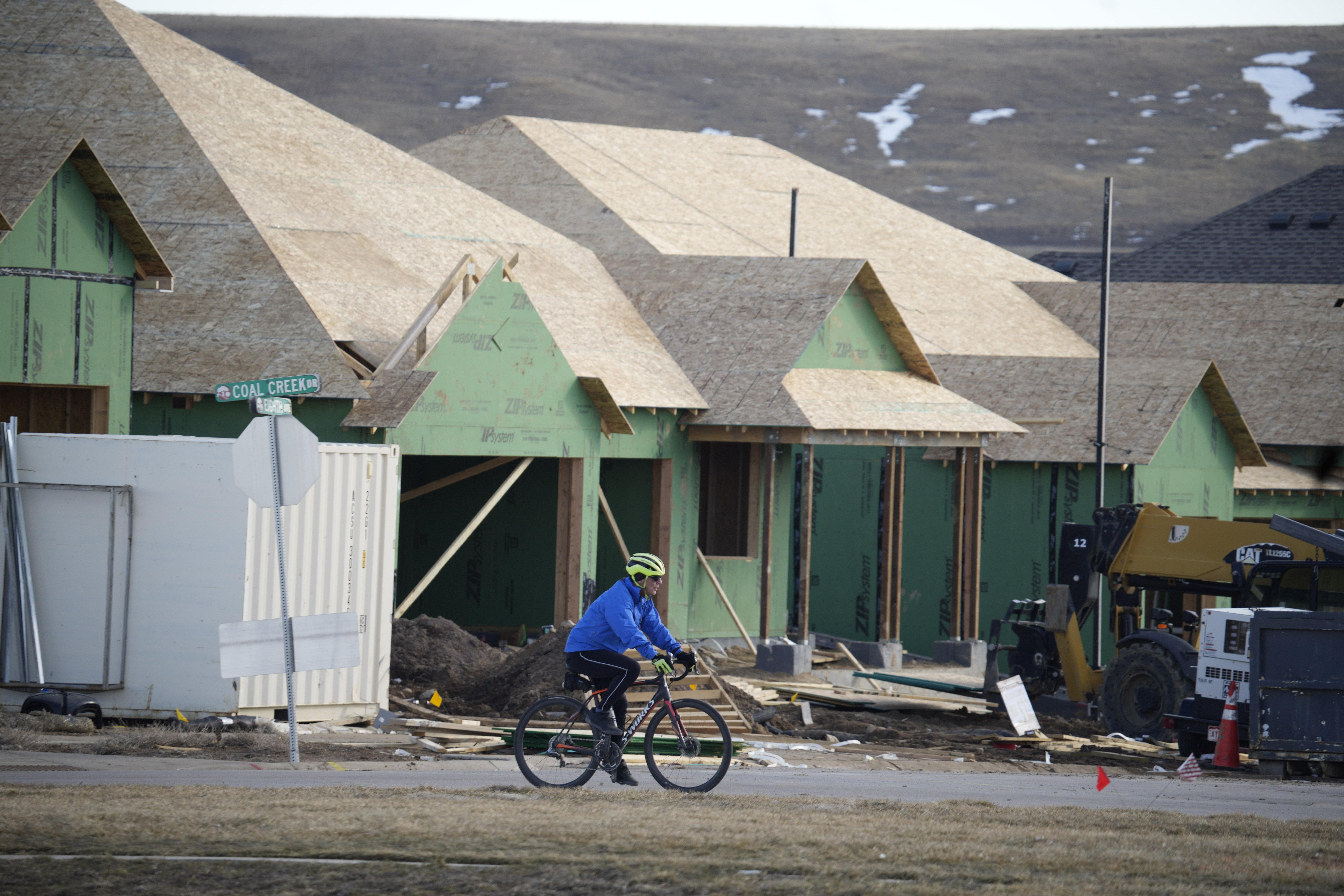 A cyclist passes by new homes under construction in a development wiped out by the Marshall Fire Sunday, Feb. 5, 2023, in Superior, Colo.<br />(David Zalubowski / AP  Photo)