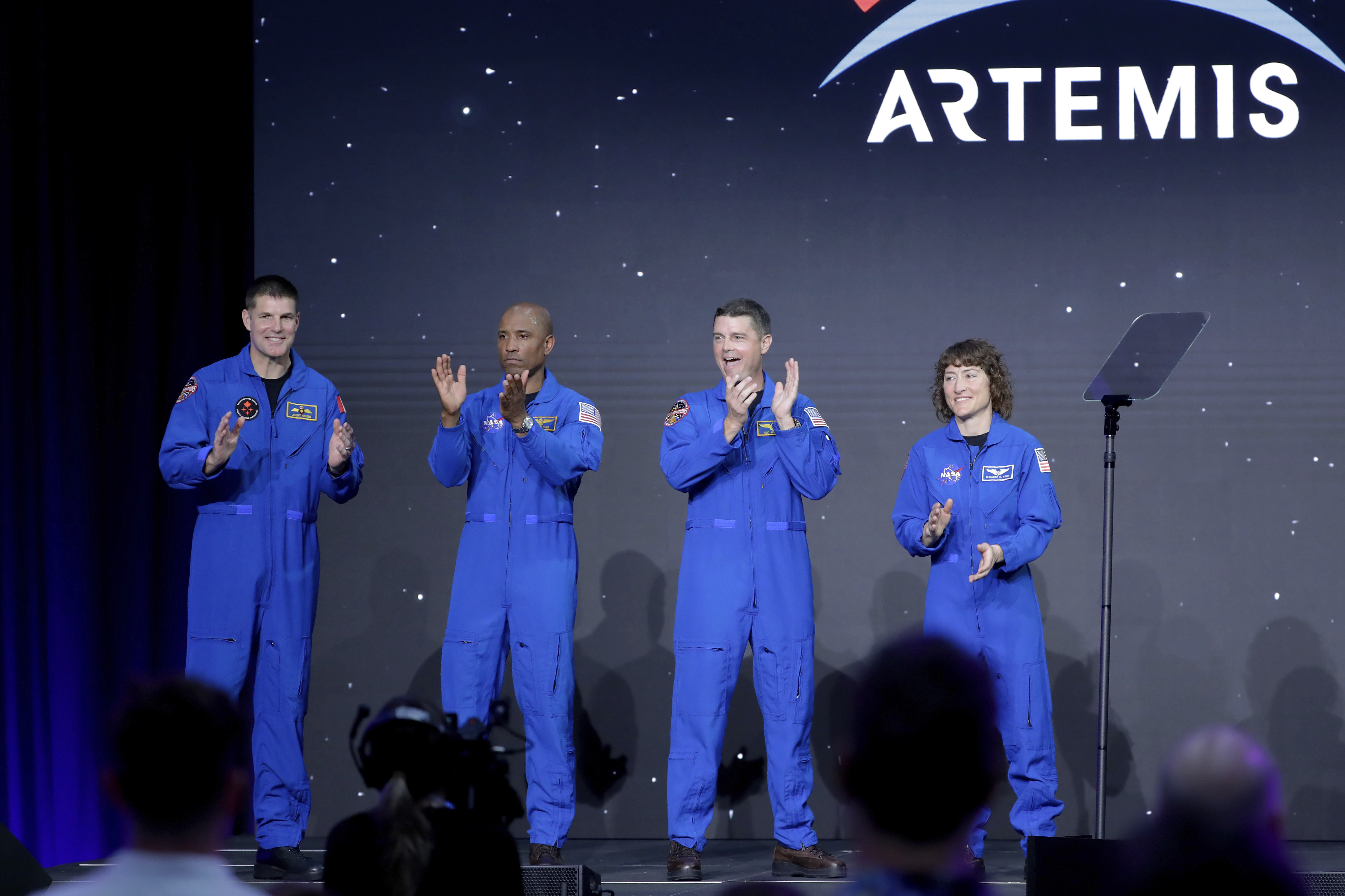 From left, Jeremy Hansen, Victor Glover, Reid Wiseman and Christina Hammock Koch, celebrate on stage as they are announced as the Artemis II crew during a NASA ceremony naming the four astronauts who will fly around the moon by the end of next year, at a ceremony held in the NASA hangar at Ellington airport Monday, April 3, 2023, in Houston. This crew will not land or even go into lunar orbit.  (Michael Wyke / AP Photo)