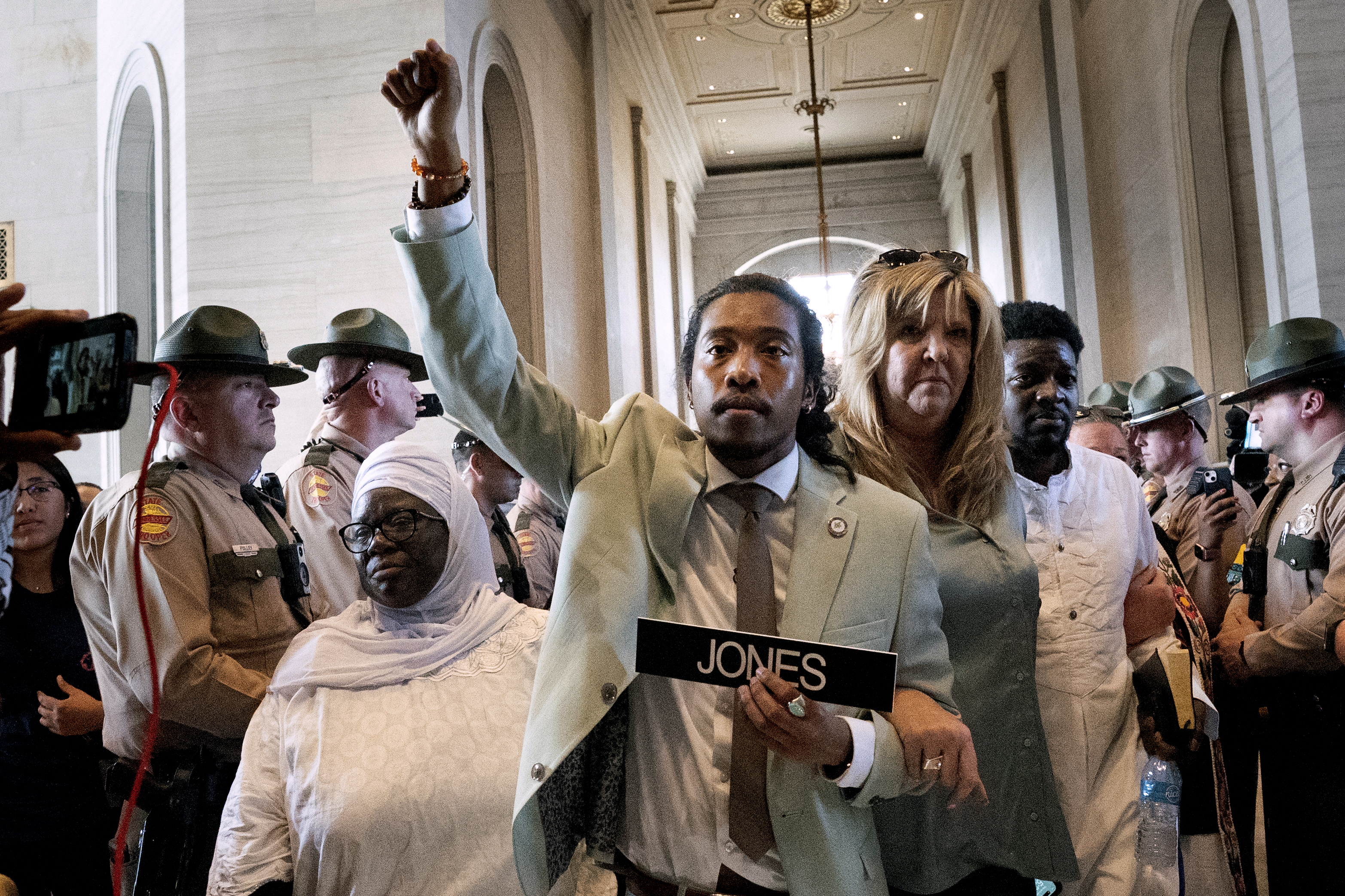 Metro Nashville Council member Zulfat Suara (left) and state Rep. Gloria Johnson, D-Knoxville (right) escort state Rep. Justin Jones, D-Nashville (center) back to the House chamber on April 10, 2023, in Nashville, Tenn. Lawmakers this year have kicked rival colleagues out of office in Tennessee and off the chamber floor in Montana. (George Walker IV / AP Photo)