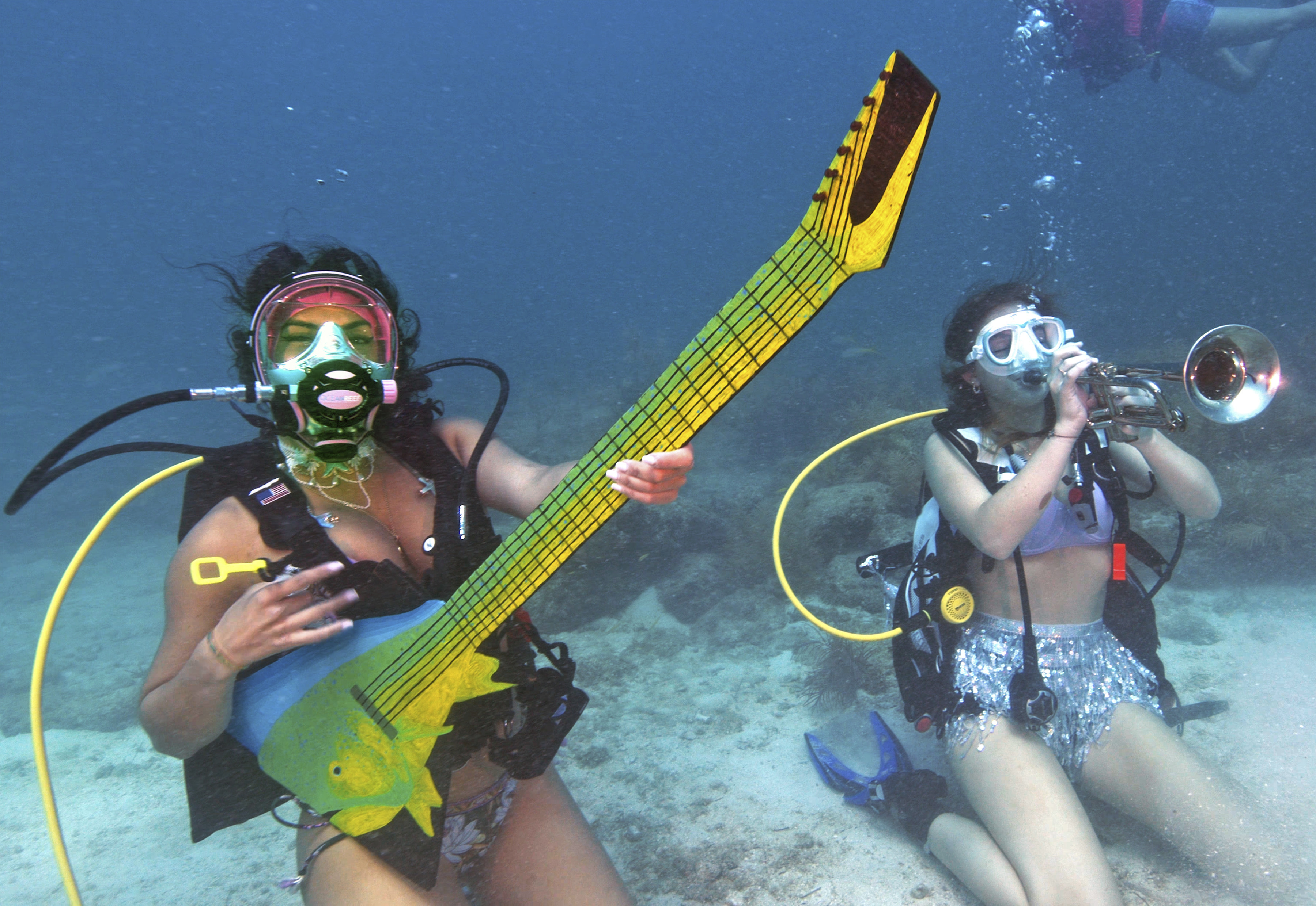 Kelly Angel, left, and Kara Norman pretend to play underwater musical instruments, Saturday, July 8, 2023, at the Lower Keys Underwater Music Festival in the Florida Keys National Marine Sanctuary near Big Pine Key, Fla. (Frazier Nivens / Florida Keys News Bureau via AP)