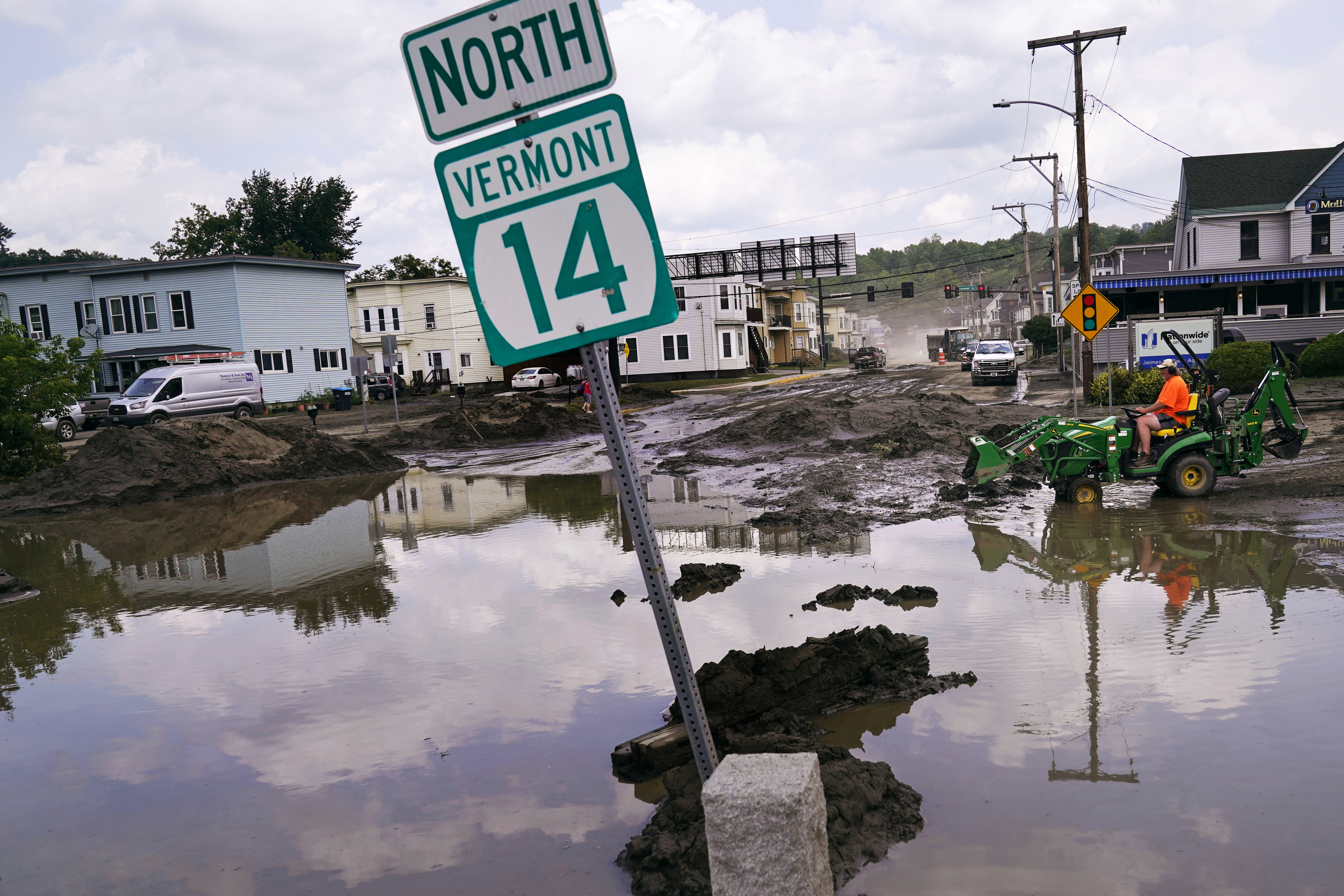 A small tractor clears water from a business as flood waters block a street, Wednesday, July 12, 2023, in Barre, Vt..<br />(Charles Krupa / AP Photo)