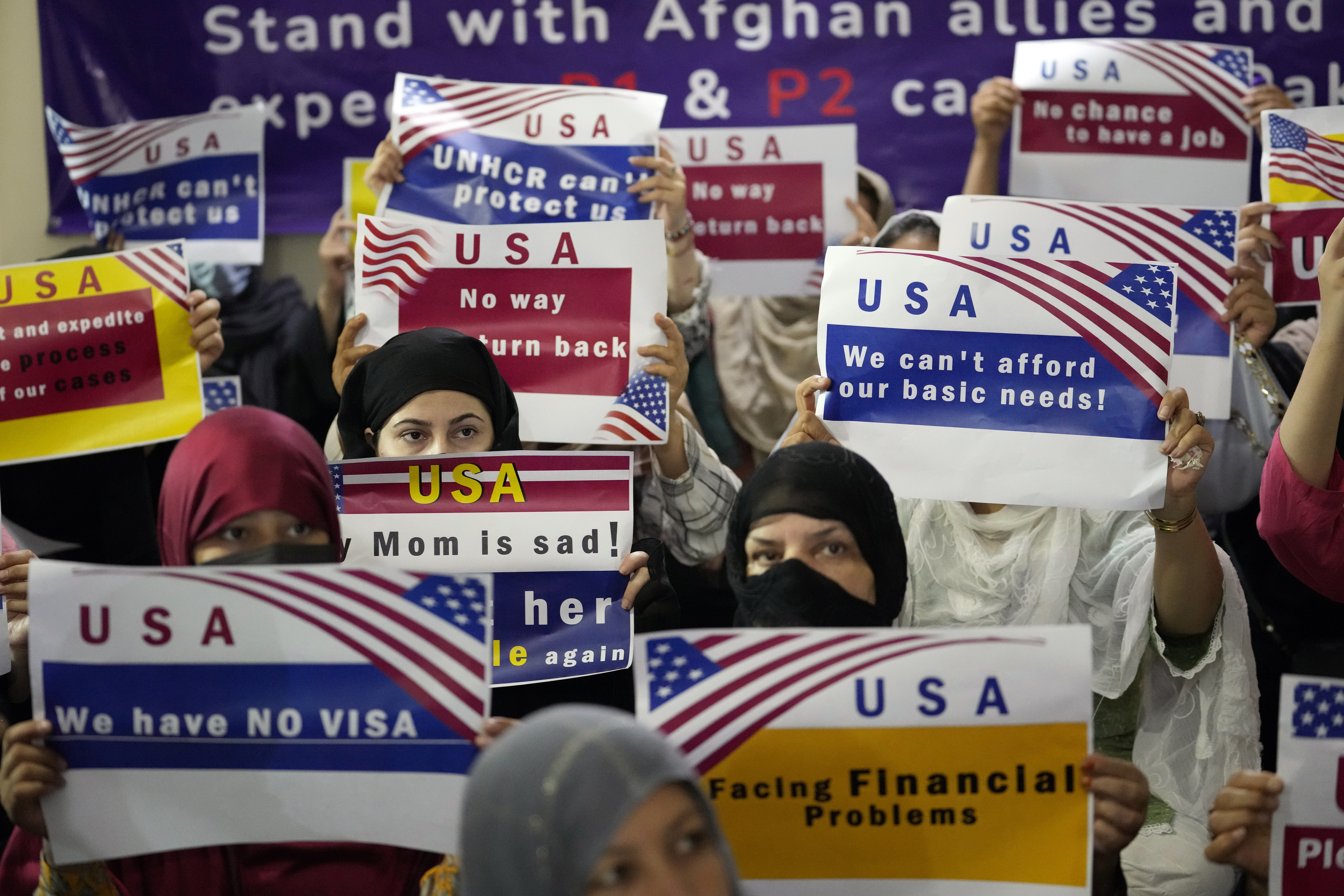 Afghan refugees hold placards protesting a delay in U.S. visas during a gathering in Islamabad, Pakistan, in July 2023. Two years after the end of the war, thousands of Afghans who helped the U.S. were still waiting for visas.<br />(Rahmat Gul / AP Photo)