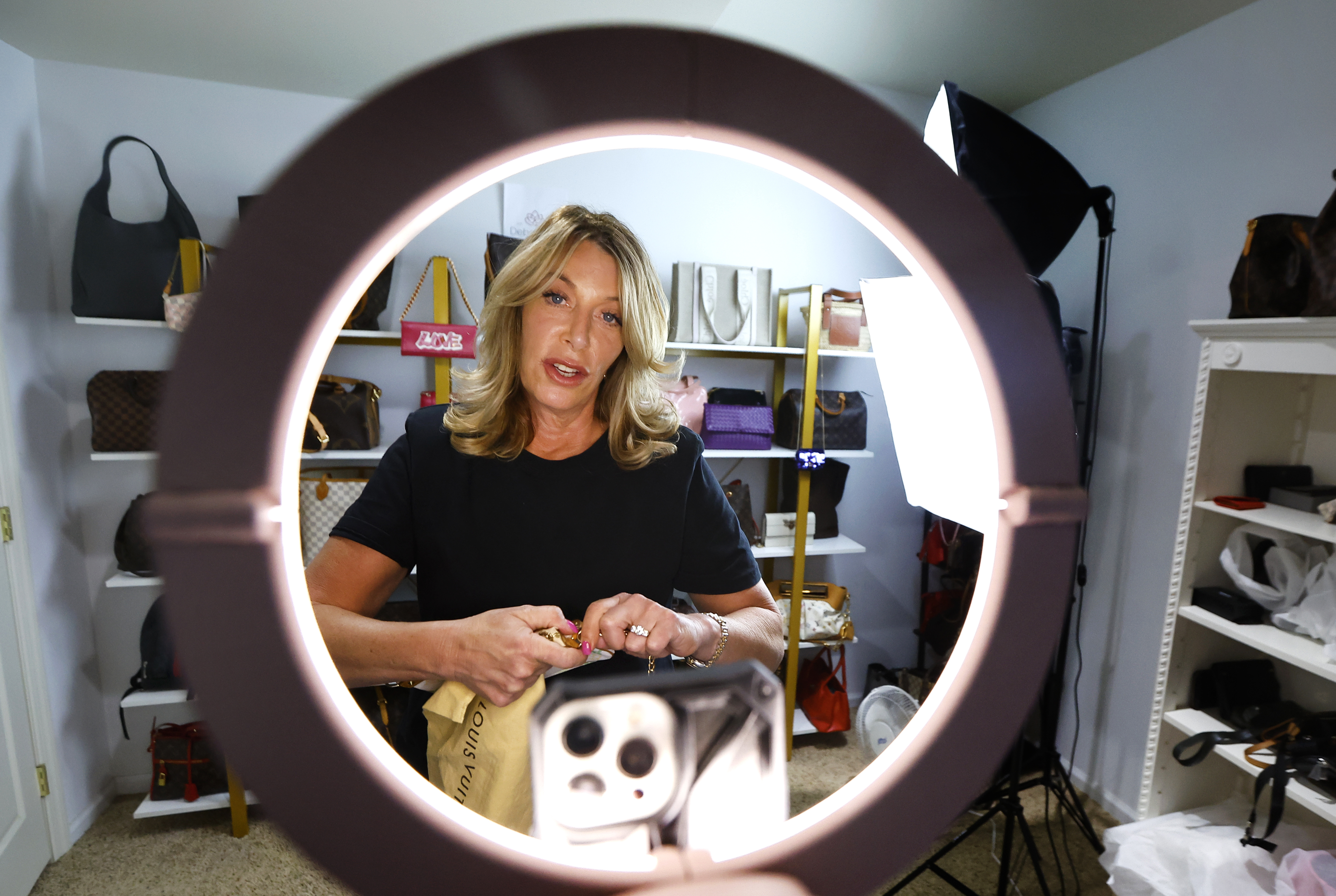 Deborah Mayer works on a livestream on TikTok on Wednesday, March 21, 2024, in Freehold, N.J. Mayer has sold new and pre-owned handbags and other designer goods out of her New Jersey home for 16 years. Early last year, TikTok recruited her business for the live component of TikTok Shop.<br />(Noah K. Murray / AP Photo)