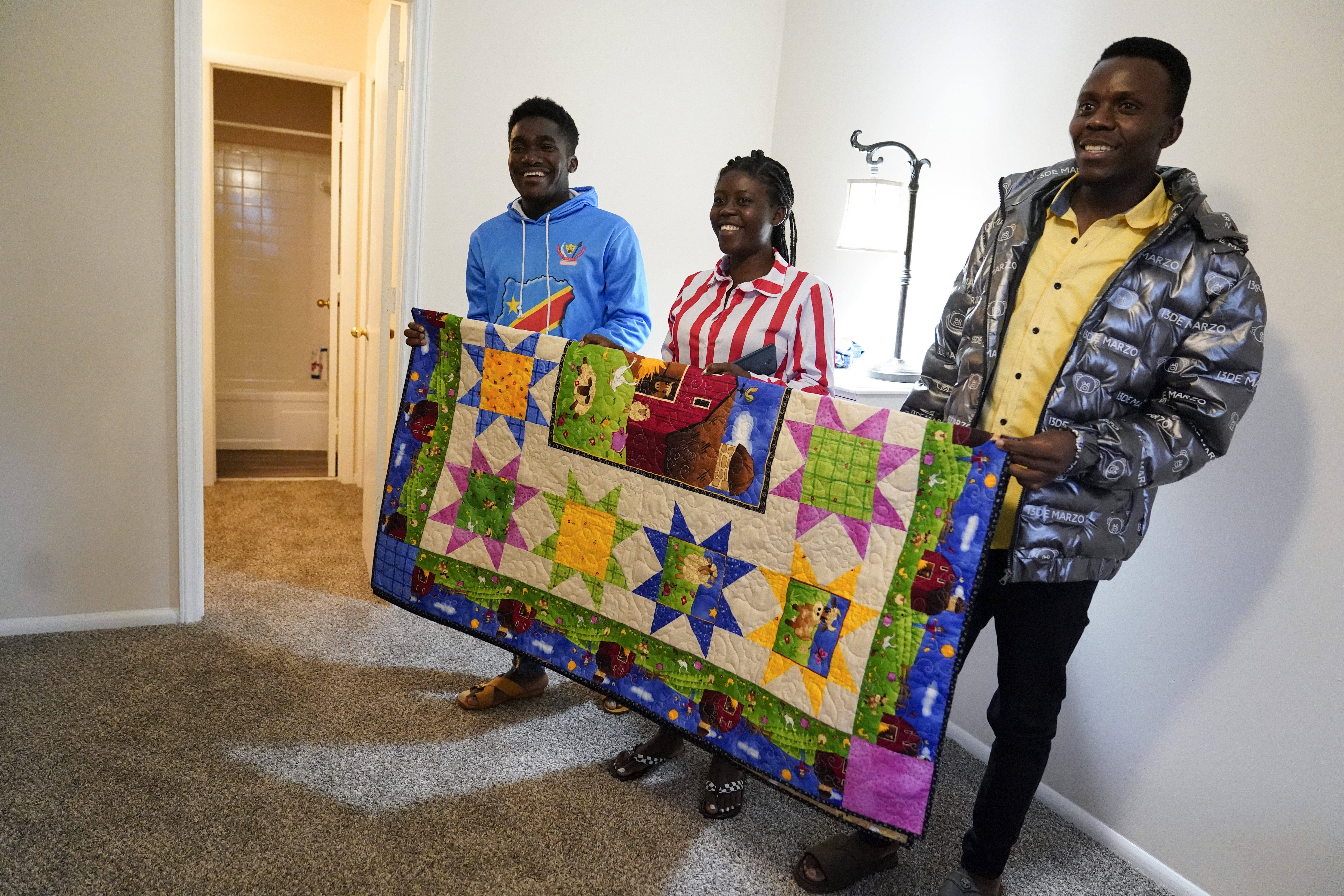 Refugees from Congo left to right: Sadock Ekyochi, his wife Riziki Kashindi and her brother Kaaskile Kashindi pose for a photo inside their new apartment, Thursday, April 11, 2024, in Columbia, S.C.<br />(Erik Verduzco / AP Photo)