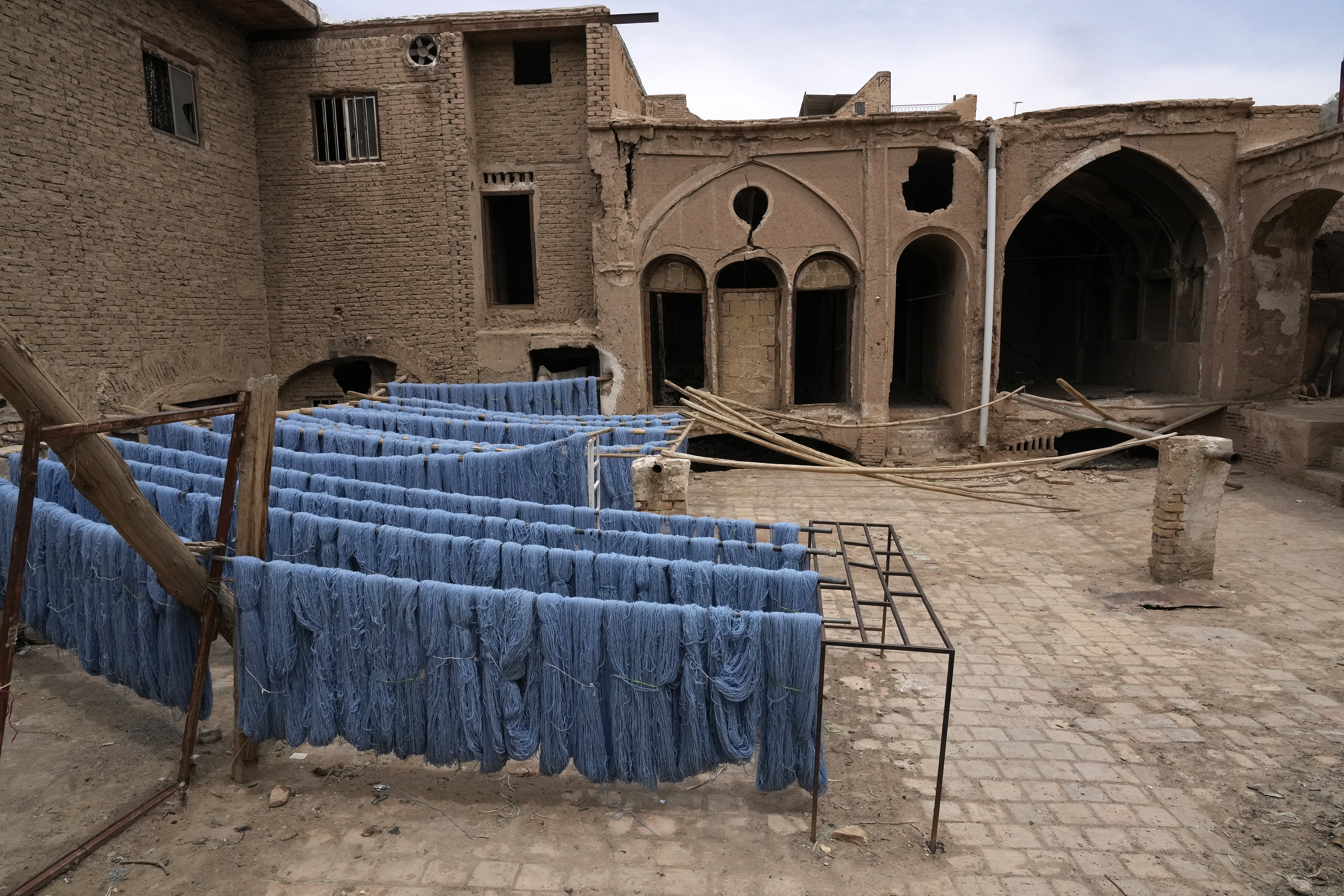 Batches of thread for hand-woven carpets that have been dyed are left to dry in the sun at a workshop at the traditional bazaar of the city of Kashan, about 152 miles (245 km) south of the capital Tehran, Iran, Tuesday,  April 30,  2024.<br />(Vahid Salemi / AP Photo)