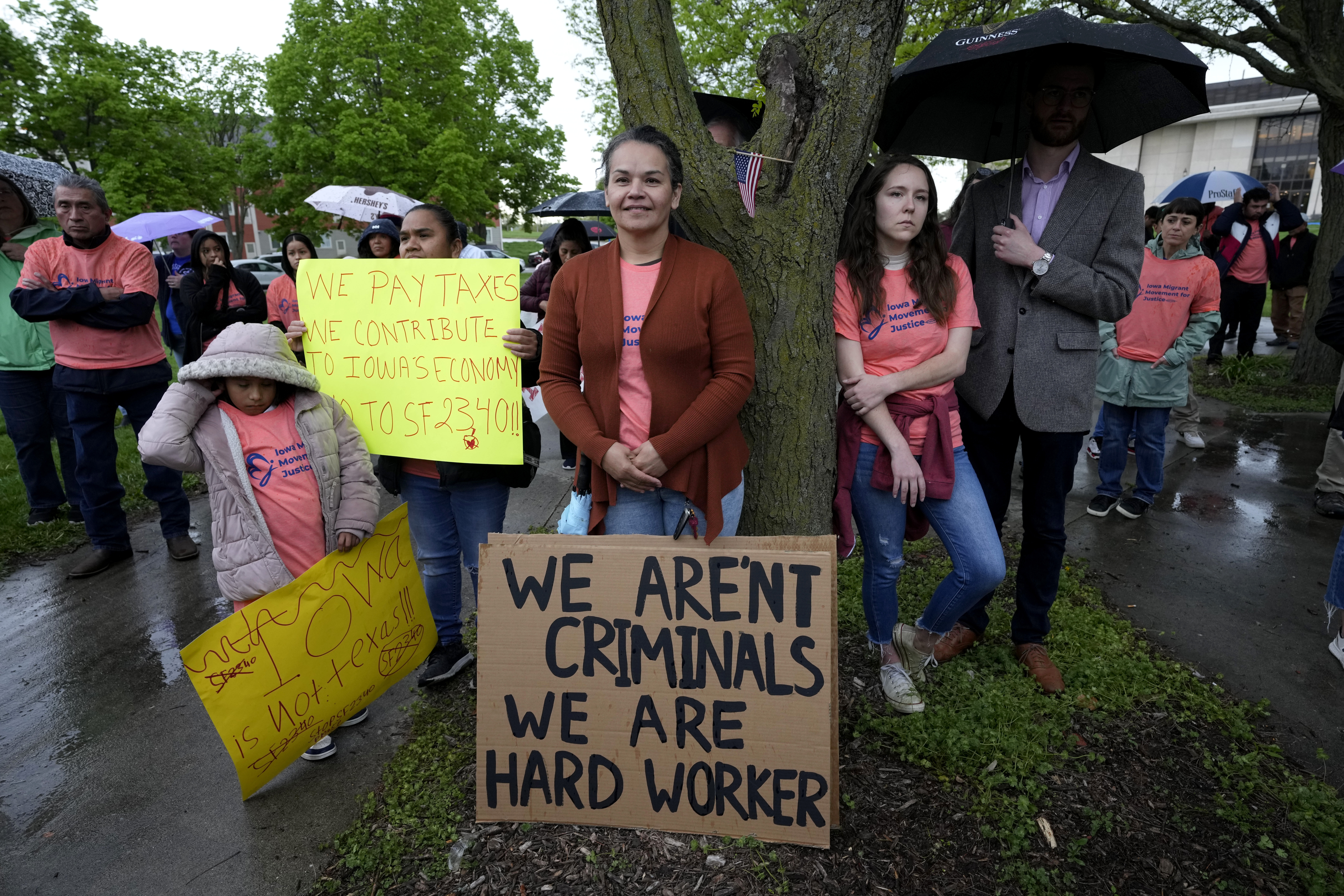 People listen to a speaker during an Iowa Movement for Migrant Justice rally and march, Wednesday, May 1, 2024, in Des Moines, Iowa. Civil rights and immigrant rights groups Thursday, May 9, 2024, are suing Iowa over a new law that makes it a crime to be in the state if previously denied admission to the U.S.<br />(Charlie Neibergall / AP Photo)