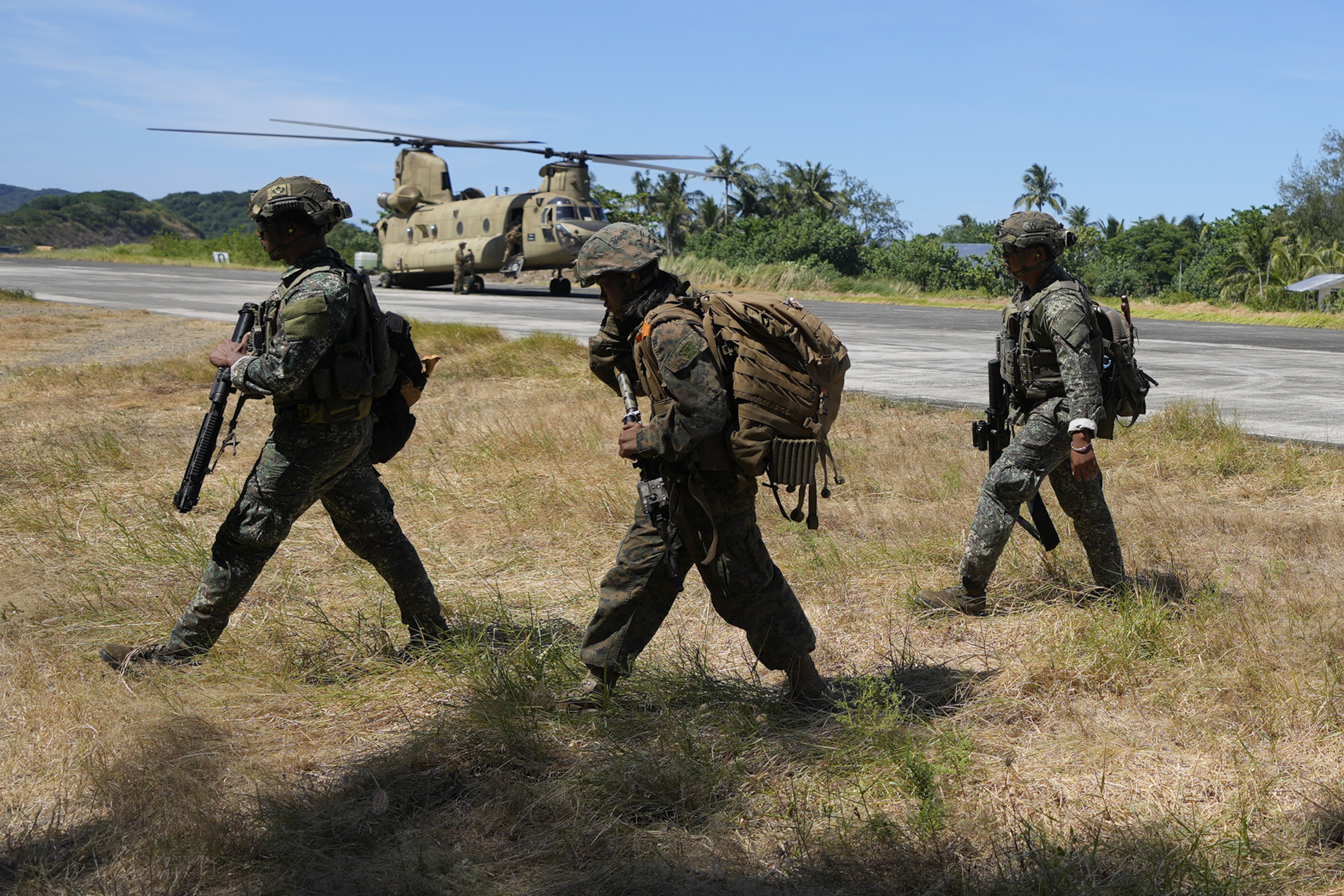 Filipino troopers walk beside a U.S. CH-47 helicopter inside the Naval Base Camilo Osias in Santa Ana, Cagayan province, northern Philippines after participating in joint military exercises on Monday, May 6, 2024.<br /> (Aaron Favila/ AP Photo)