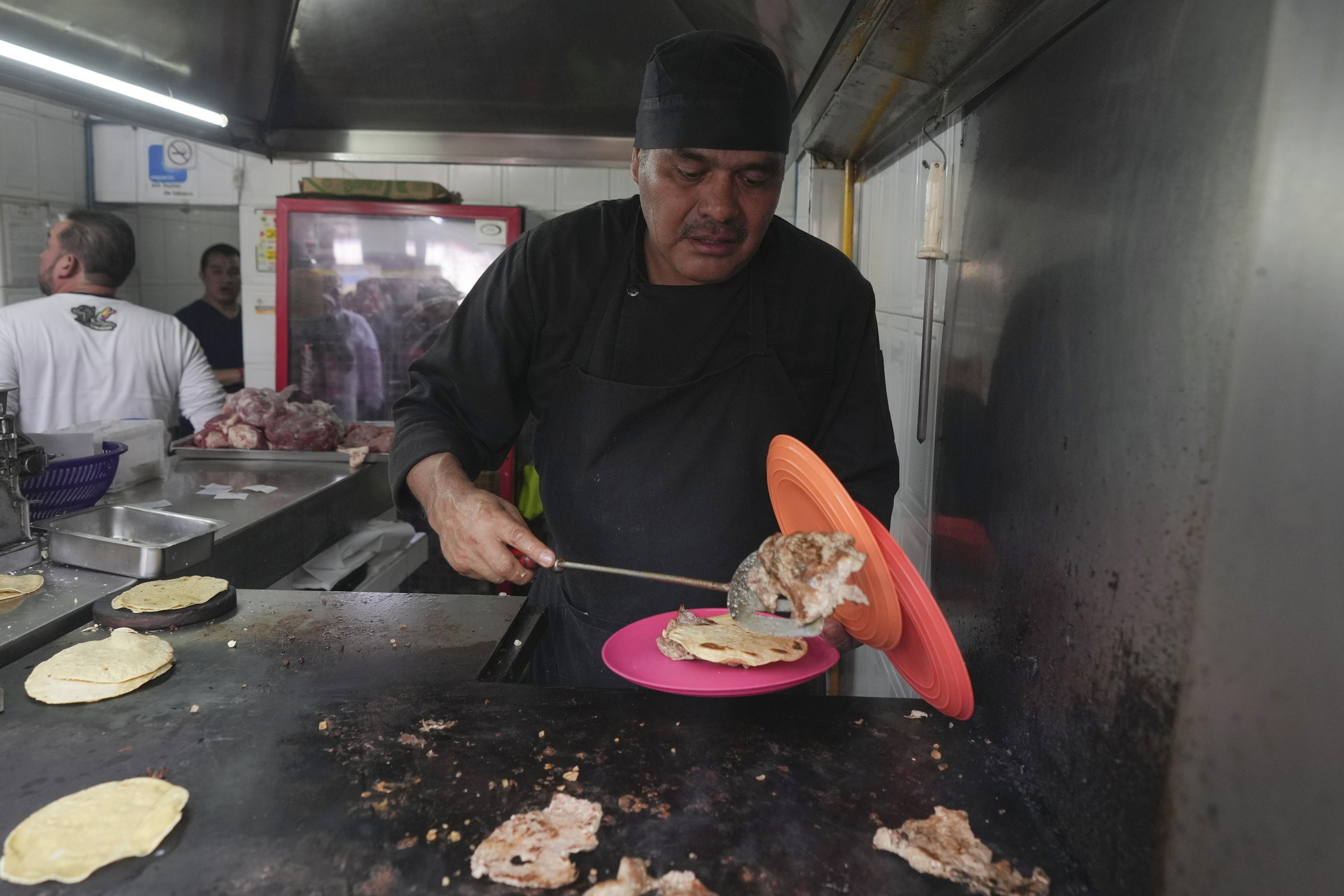 Newly minted Michelin-starred chef Arturo Rivera Martínez prepares an order of tacos at the Tacos El Califa de León taco stand, in Mexico City, Wednesday, May 15, 2024. Tacos El Califa de León is the first ever taco stand to receive a Michelin star from the French dining guide.<br />(Fernando Llano / AP Photo)