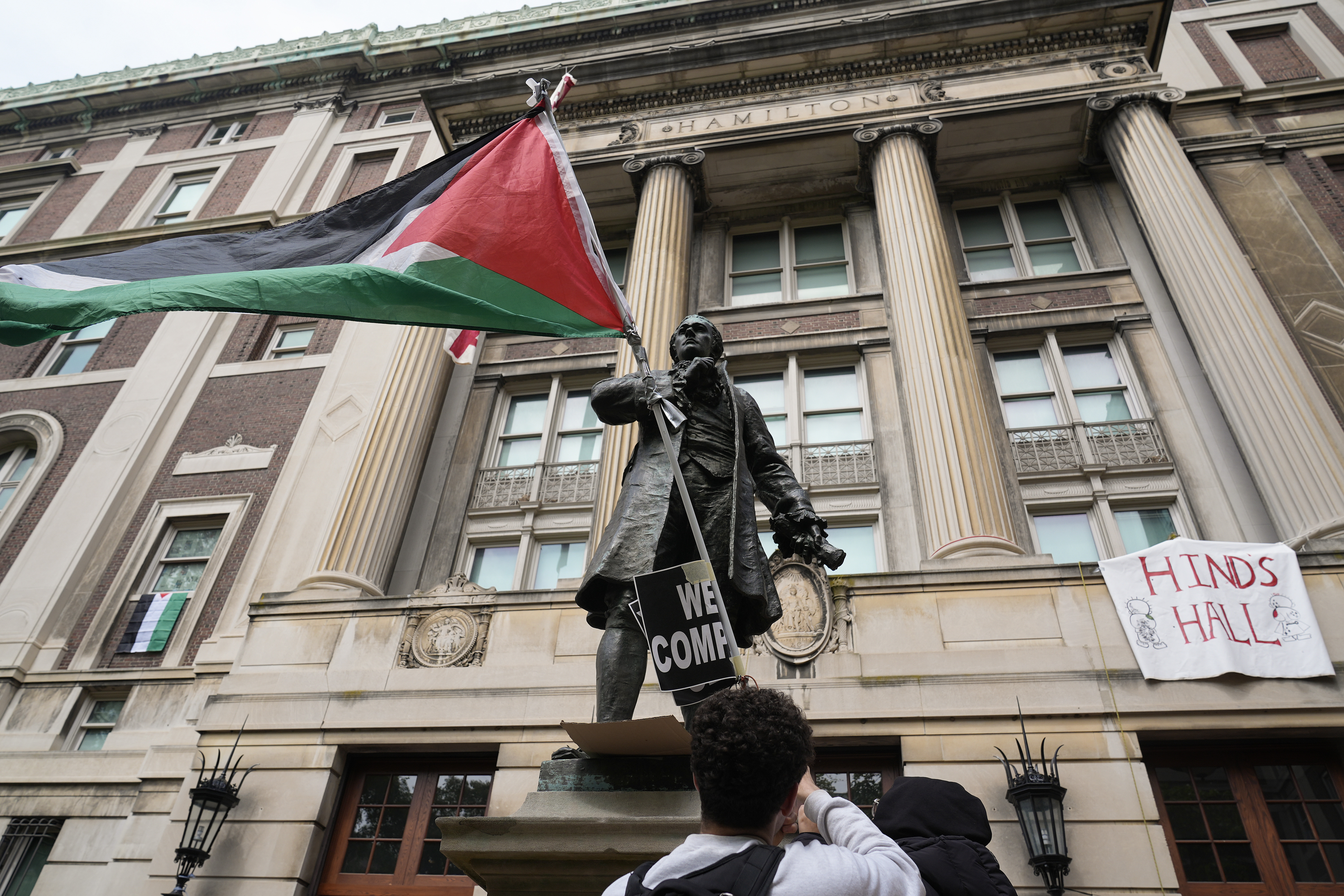 A student protester parades a Palestinian flag outside the entrance to Hamilton Hall on the campus of Columbia University in New York.<br />(Mary Altaffer / AP Photo)