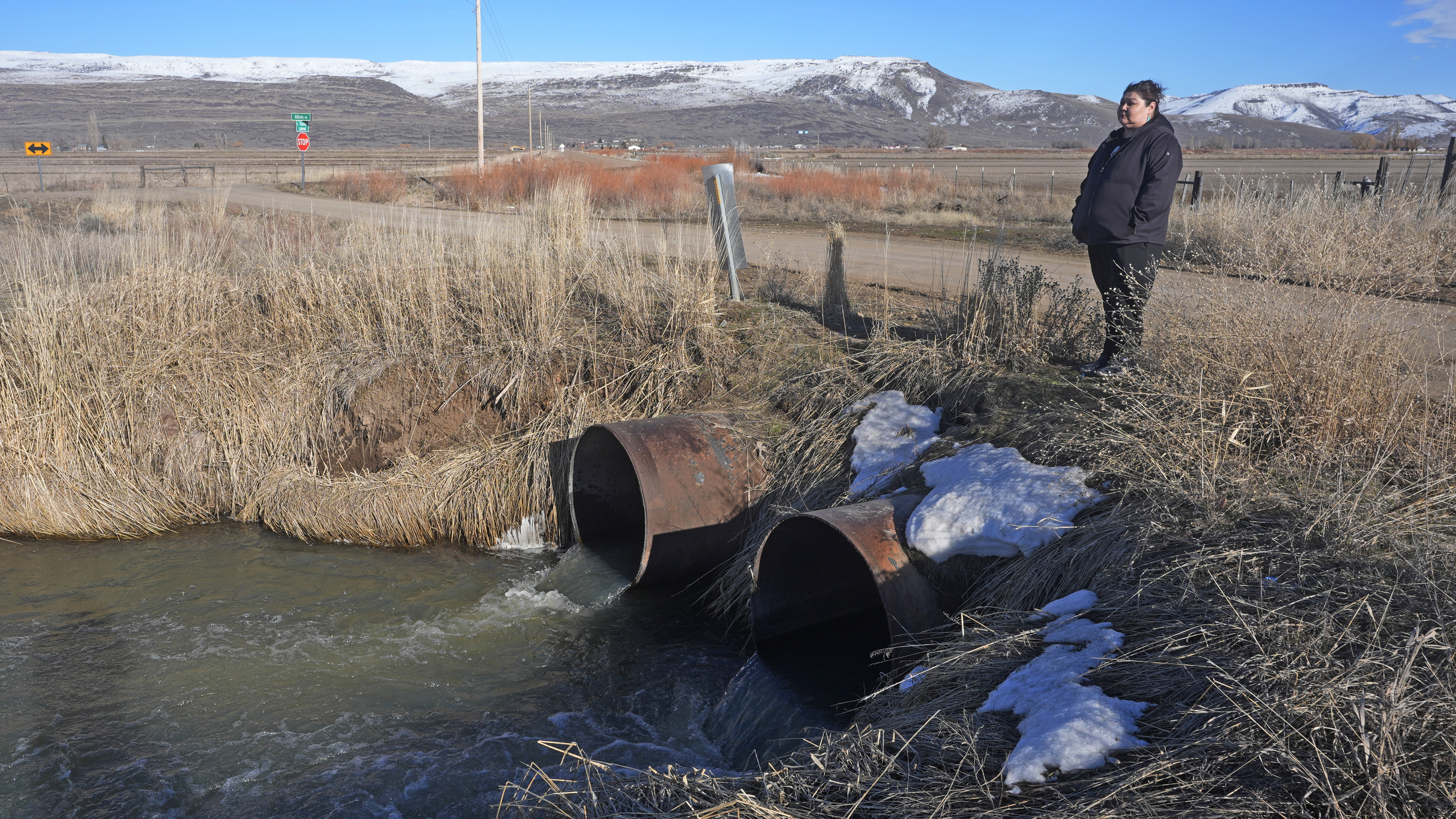 Shoshone-Paiute tribal member Tanya Smith Beaudoin stands along an irrigation canal that she grew up swimming in, on March 14, 2024, in Owyhee, Nevada.<br />(Rick Bowmer / AP Photo)