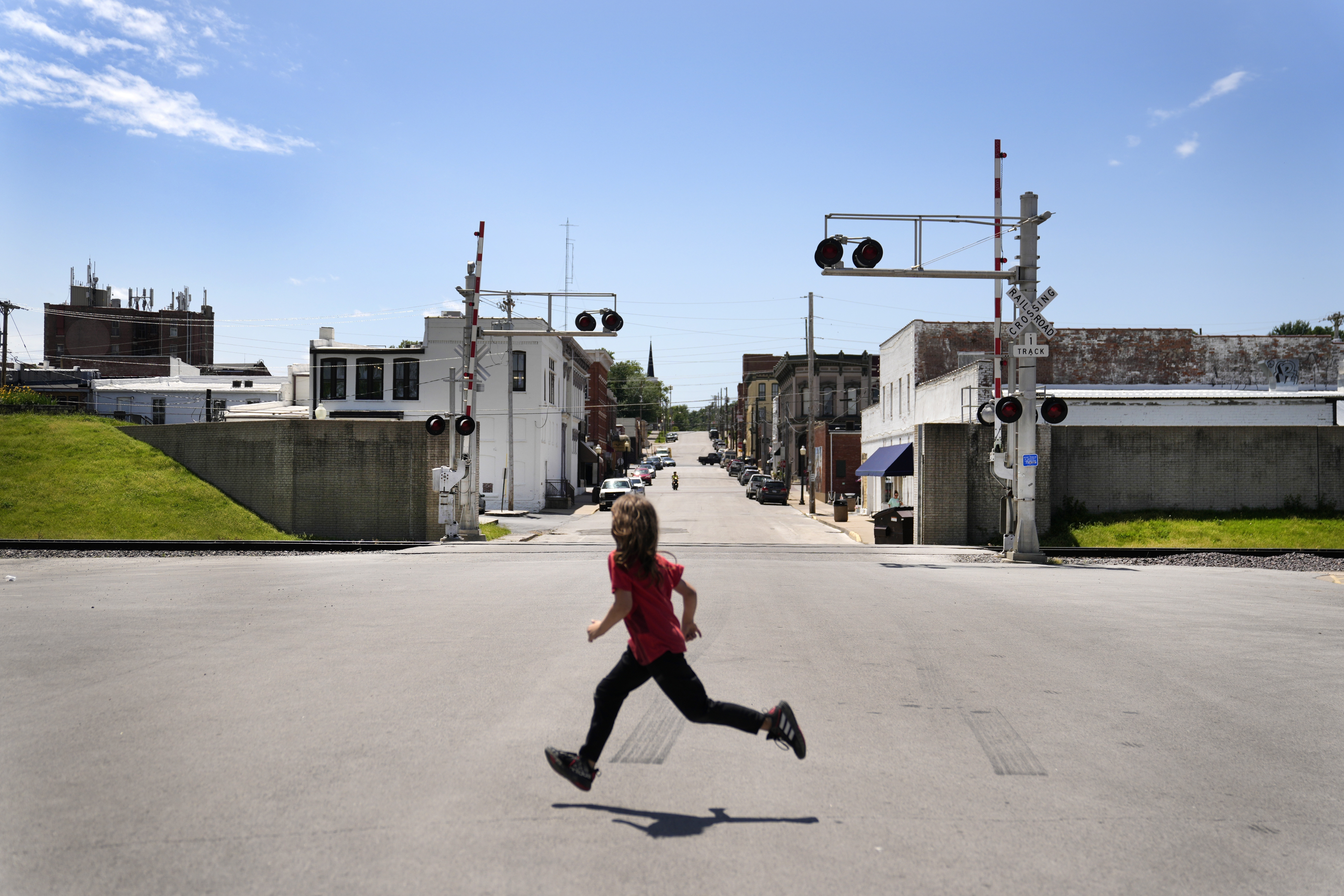 A child runs past an opening in the flood wall protecting downtown Hannibal, Mo., Wednesday, May 22, 2024. The wall protected downtown Hannibal during the flood of 1993 not long after it was completed keeping business open and tourists coming while some homes outside were swamped.<br />(Jeff Roberson / AP Photo)