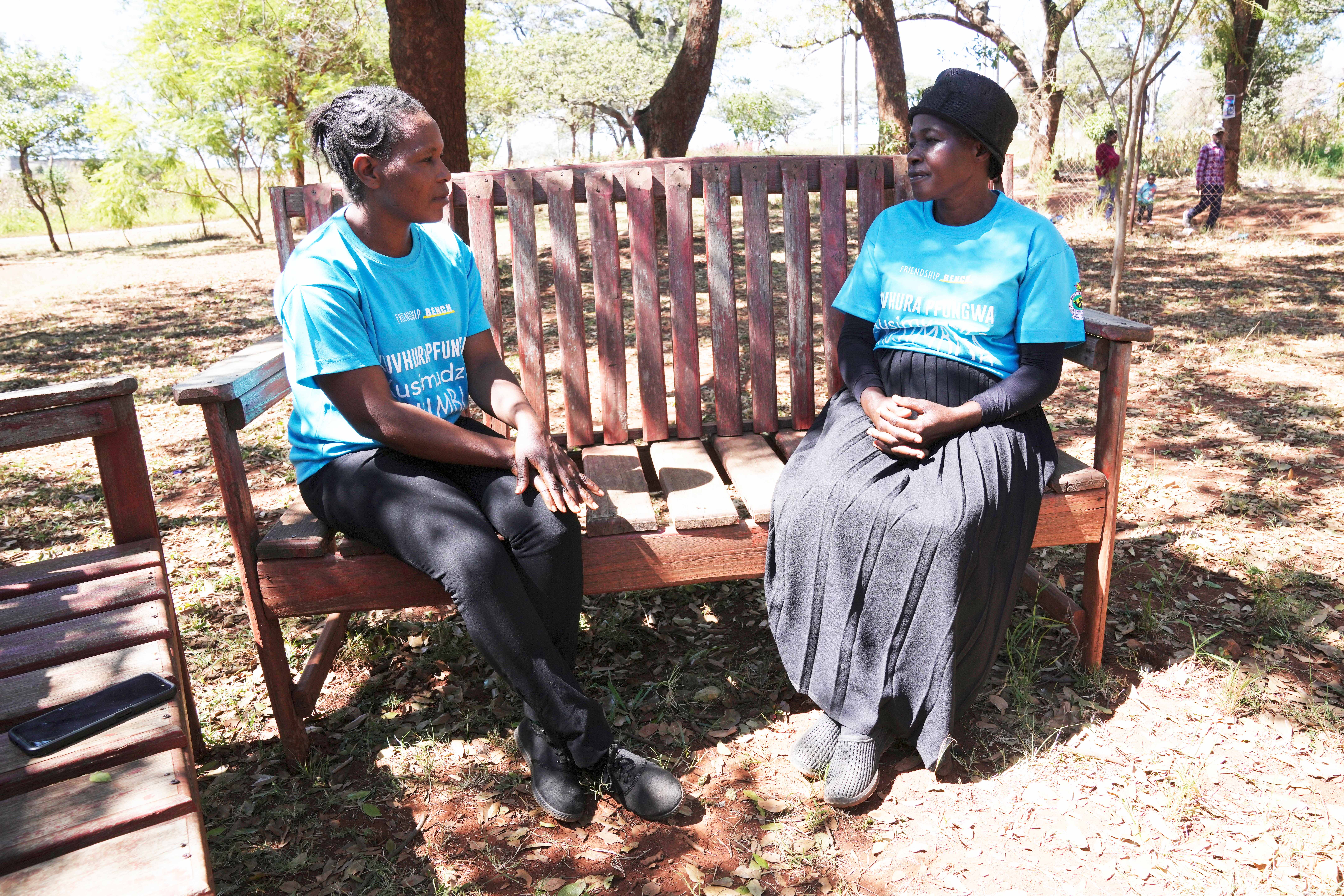Siridzayi Dzukwa, a grandmother (right) talks to a colleague while seated at a bench in Hatfcliffe on the outskirts of the capital Harare, Zimbabwe, Saturday, May 11, 2024. In Zimbabwe, talk therapy involving park benches and a network of grandmothers has become a saving grace for people with mental health issues. Now the concept is being adopted in parts of the United States and elsewhere.<br />(Tsvangirayi Mukwazhi / AP Photo)