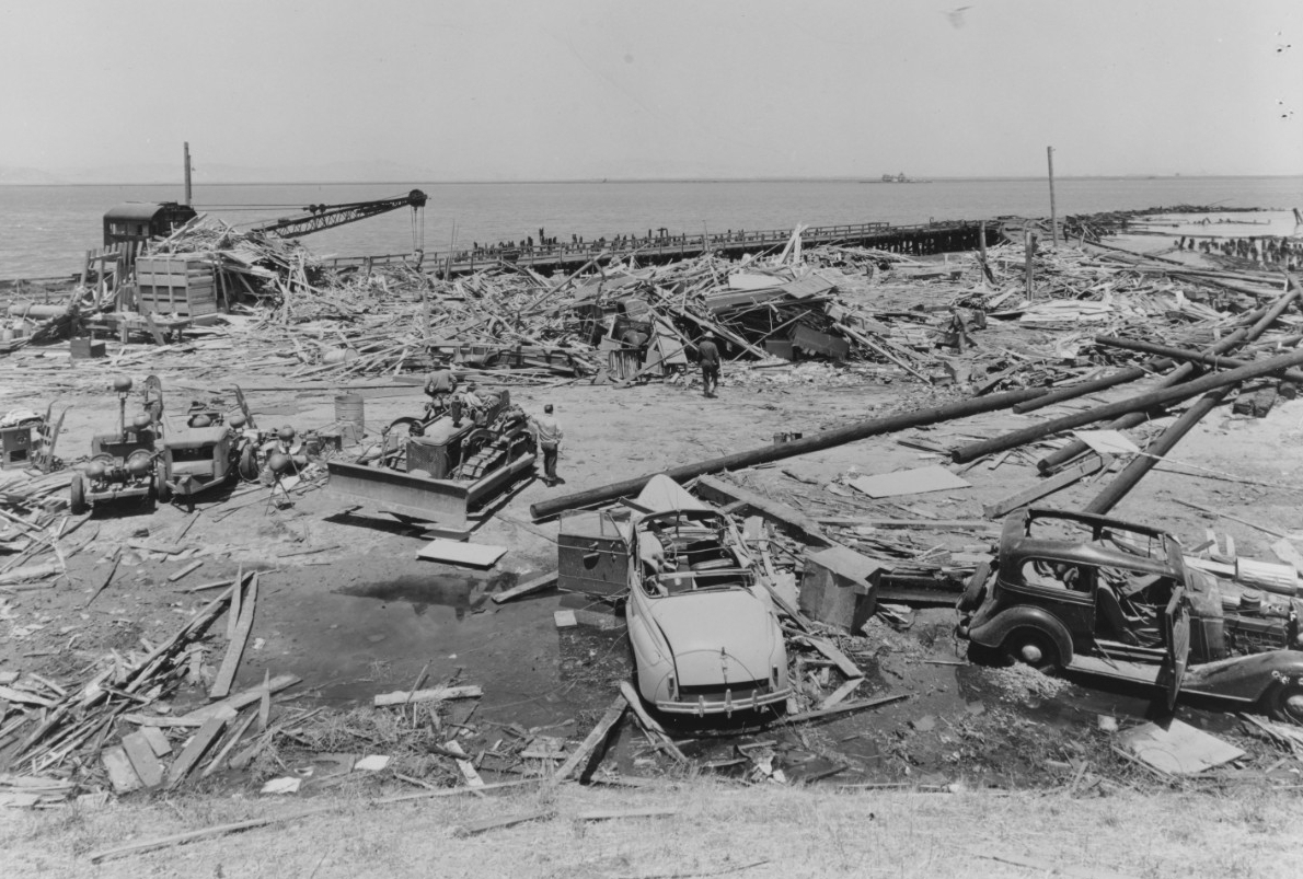 This image shows the wreckage of the Building A-7 Joiner Shop in the center and munitions pier beyond, from the July 17, 1944 explosion at Port Chicago naval weapons station near San Francisco.<br />(Naval History and Heritage Command / Mare Island Navy Yard via AP