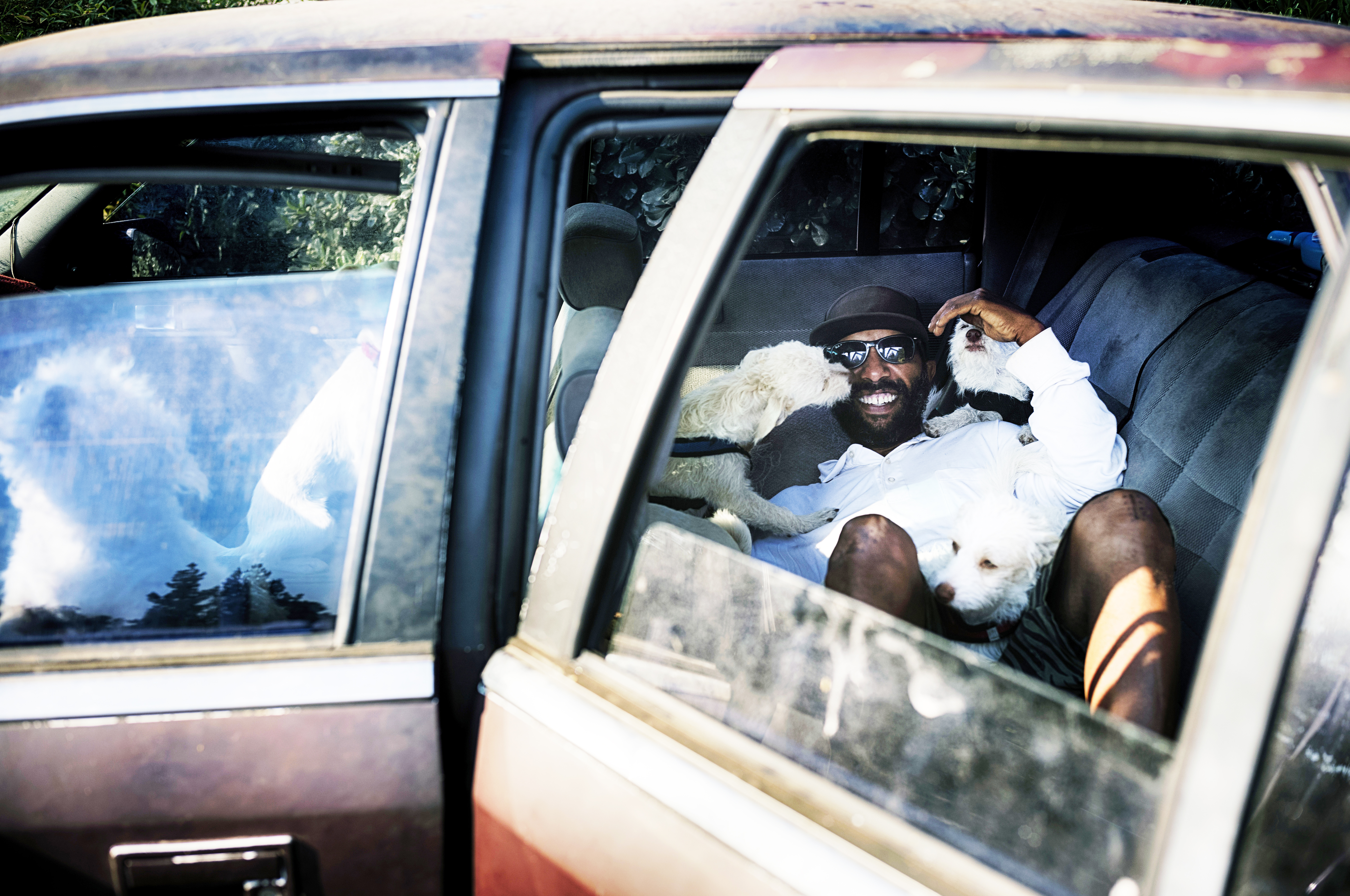 David Clarke, who is suffering homelessness and living in his car, cuddles with his six dogs early morning in a parking lot in Los Angeles on Tuesday, July 9, 2024.<br />(Richard Vogel / AP Photo, File)