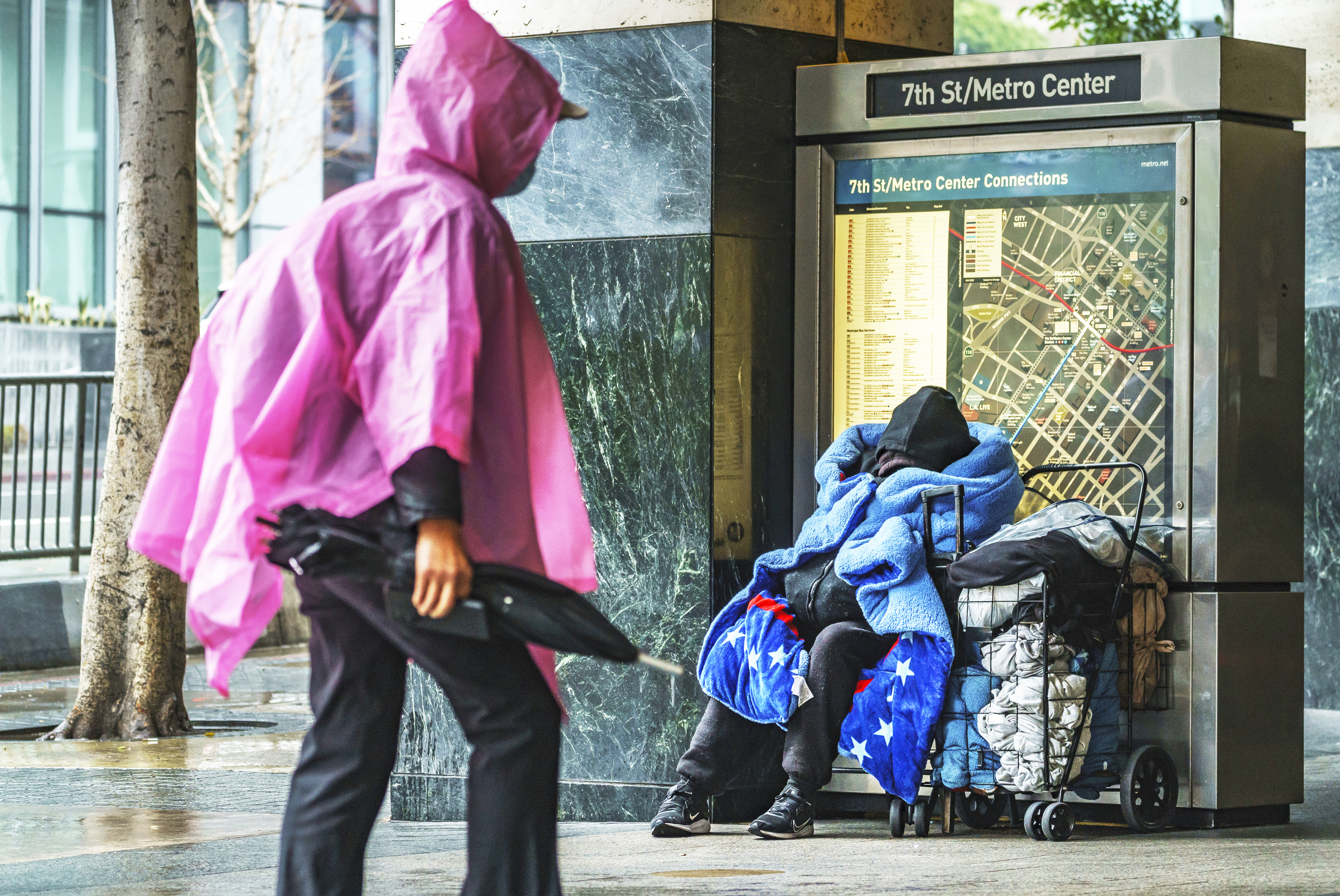 A homeless person covers up with a blanket outside the entrance to the 7th Street/Metro Center subway station in downtown Los Angeles Friday, March 19, 2023.<br />(Damian Dovarganes / AP Photo, File)