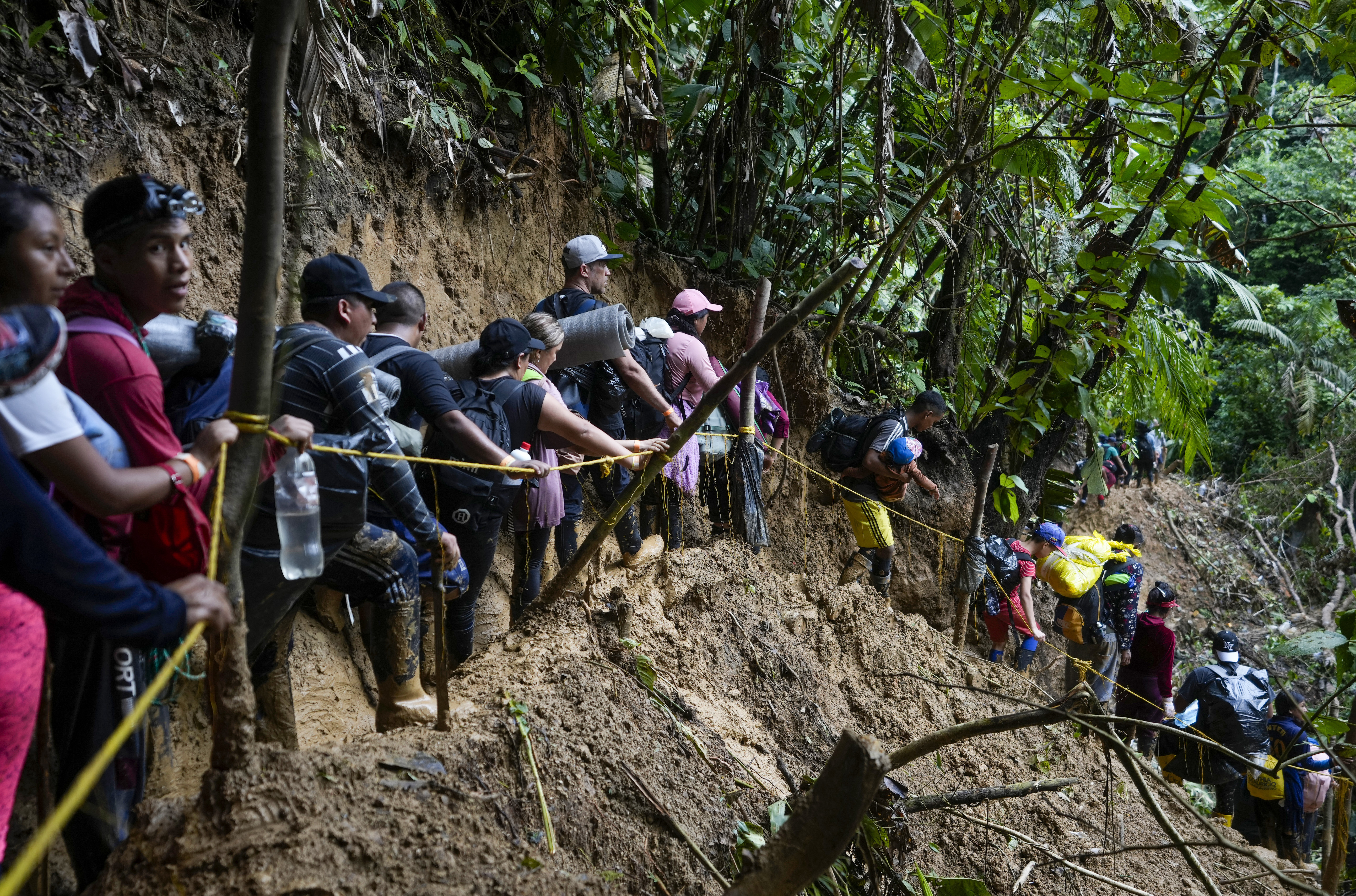 Migrants walk across the Darien Gap from Colombia into Panama, hoping to reach the U.S., Oct. 15, 2022. Some Afghans seeking asylum in Omaha traveled through the treacherous jungle to reach the U.S. after fleeing their homeland when the Taliban returned.<br />(Fernando Vergara / AP Photo)