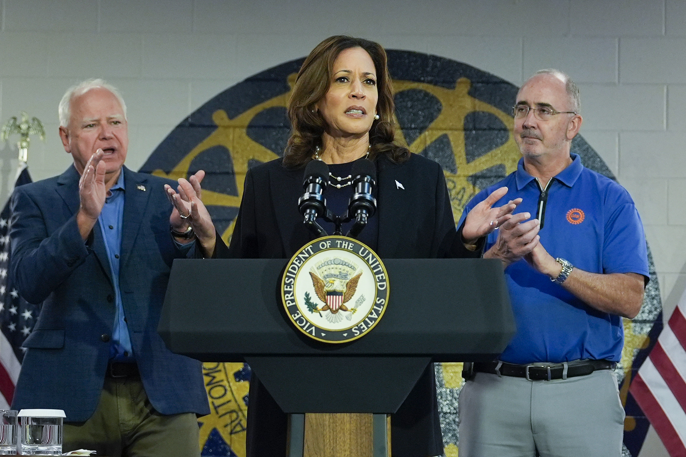 Democratic presidential nominee Vice President Kamala Harris, with Democratic vice presidential nominee Minnesota Gov. Tim Walz (left) and Shawn Fain, President of the UAW (right) speaks at a campaign rally at UAW Local 900, Thursday, August 8, 2024, in Wayne, Mich.<br />(Julia Nikhinson / AP Photo)