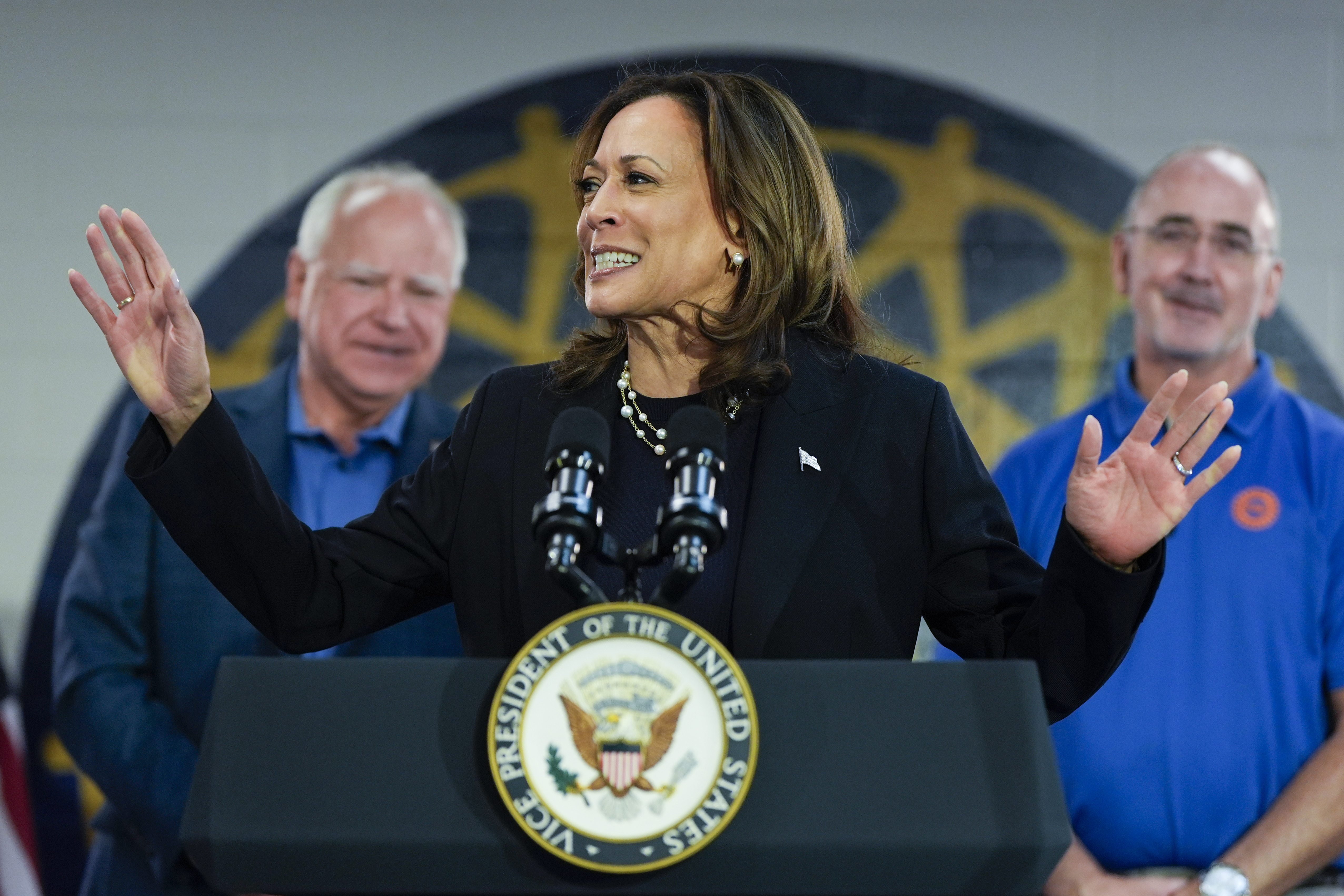 Democratic presidential nominee Vice President Kamala Harris, with Democratic vice presidential nominee Minnesota Gov. Tim Walz (left) and UAW President Shawn Fain, speaks at a campaign rally at UAW Local 900, Thursday, August 8, 2024, in Wayne, Mich.<br />(Julia Nikhinson / AP Photo)