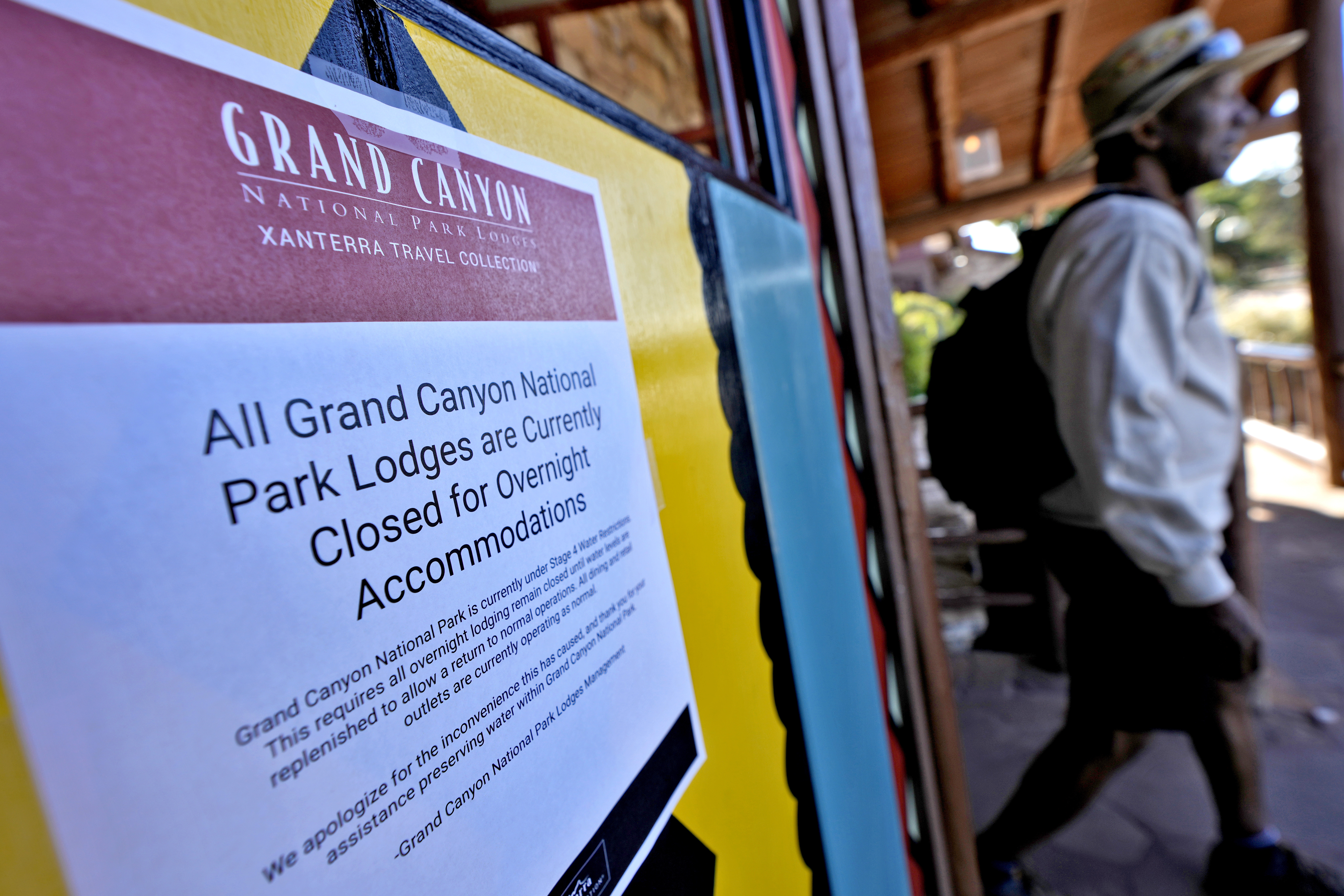 A sign denoting park lodge closures hangs on the door as a guest exits the Bright Angel Lodge, Thursday, Aug. 29, 2024, in Grand Canyon, Ariz.<br />(Matt York / AP Photo)