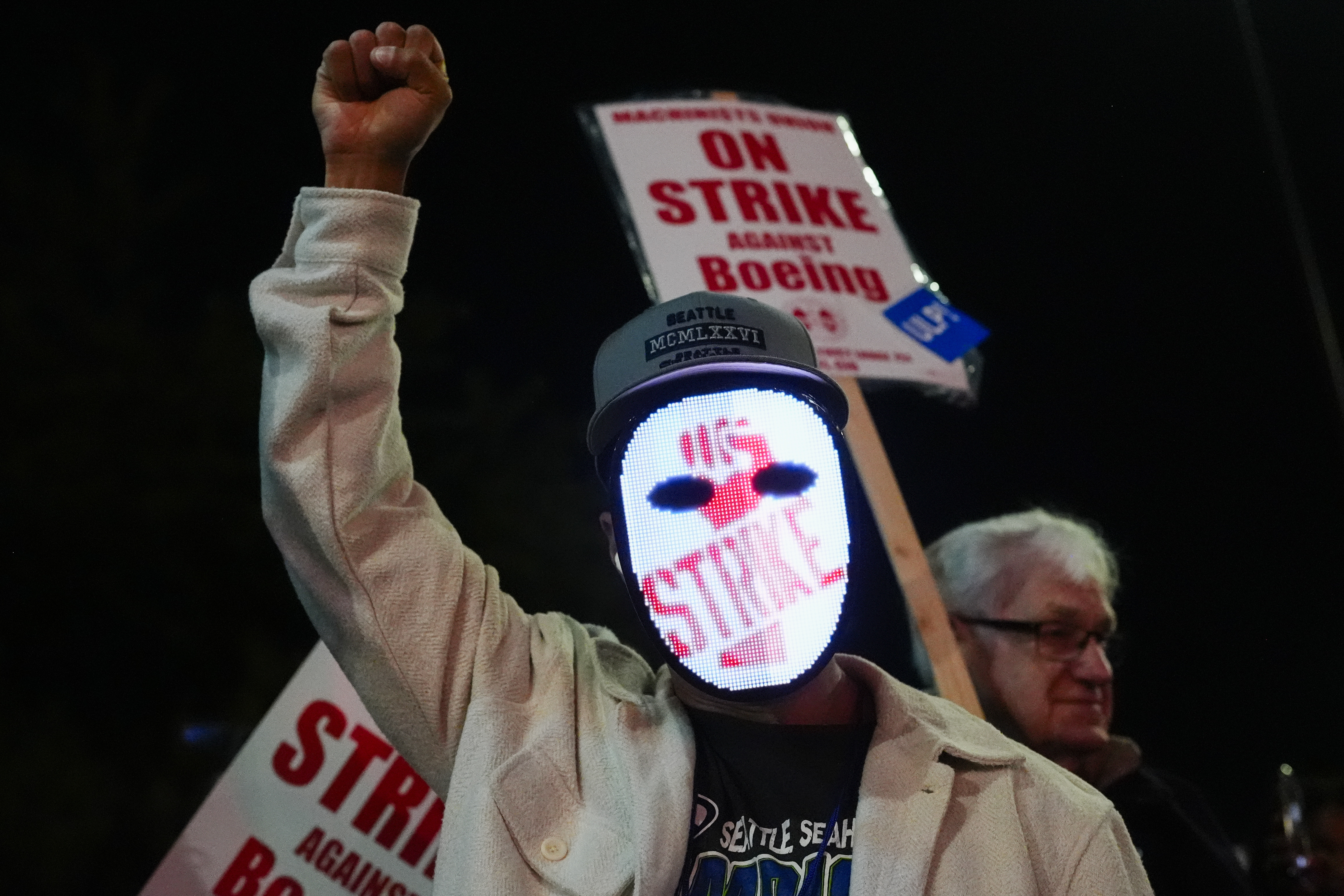 A Boeing worker wears a mask with a digital &quot;strike&quot; sign as Boeing employees picket.<br />(Lindsey Wasson / AP Photo)