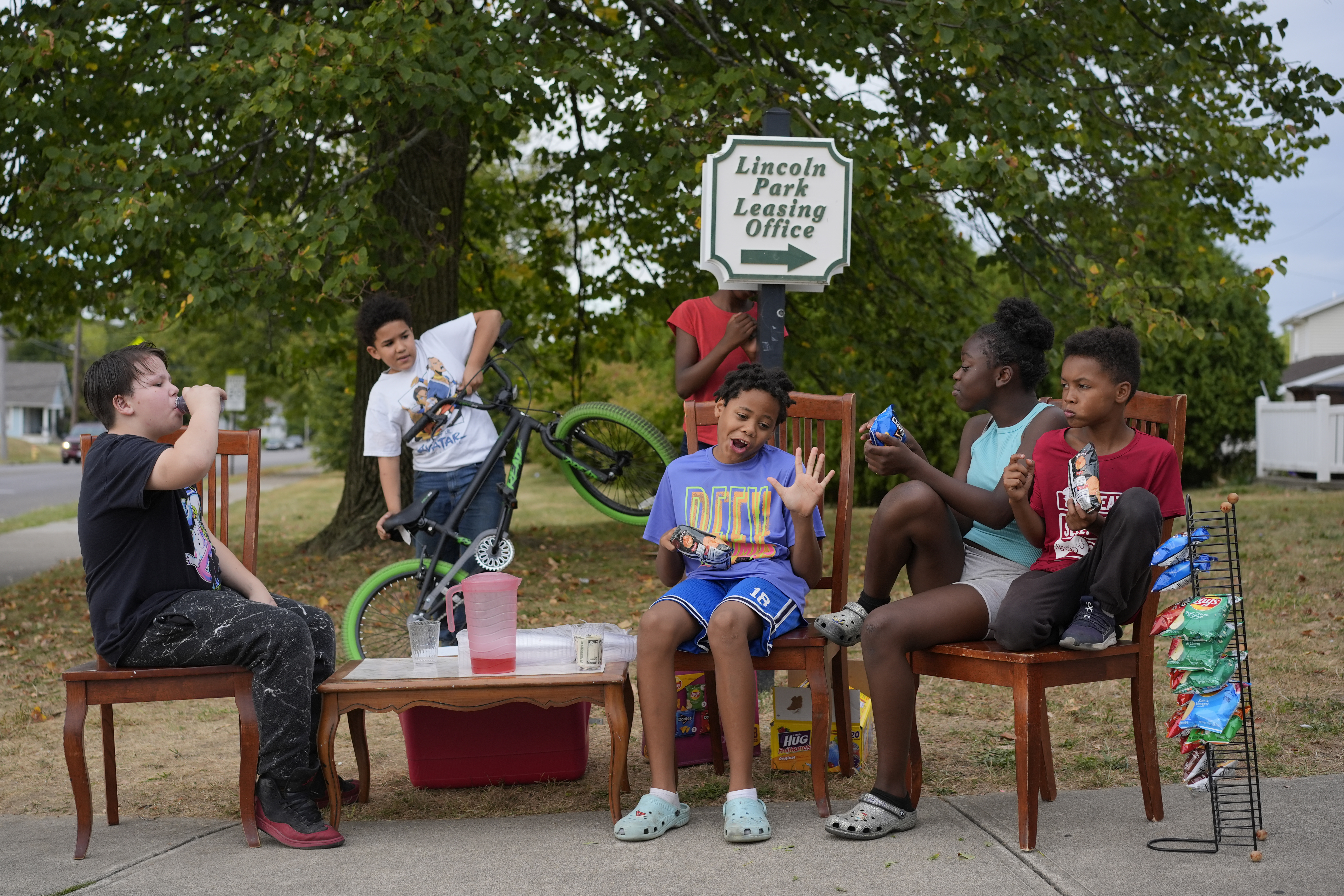 Neighborhood kids gather to sell Kool-Aid and chips, Tuesday, Sept. 17, 2024, in Springfield, Ohio. Some were kept home from school because of the bomb threats at their schools, and if that happens again, they plan to be at the corner with Kool-Aid and chips again tomorrow.<br />(Carolyn Kaster / AP Photo)