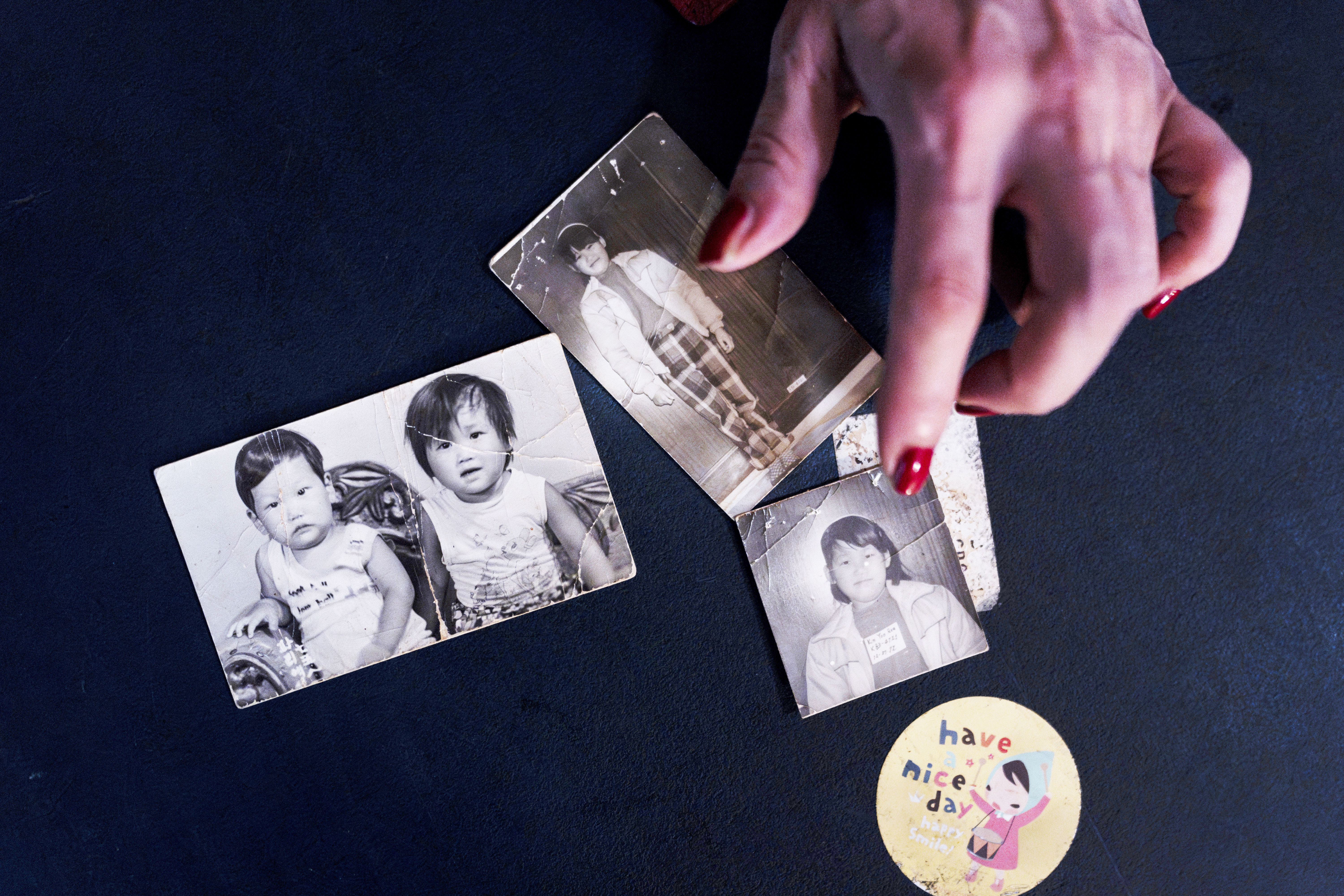 Yooree Kim, who was sent to a couple in France by the Holt adoption agency when she was 11, displays some old photos of her and her brother in her apartment in Seoul, Saturday, May 18, 2024.<br />(Jae C. Hong / AP Photo)