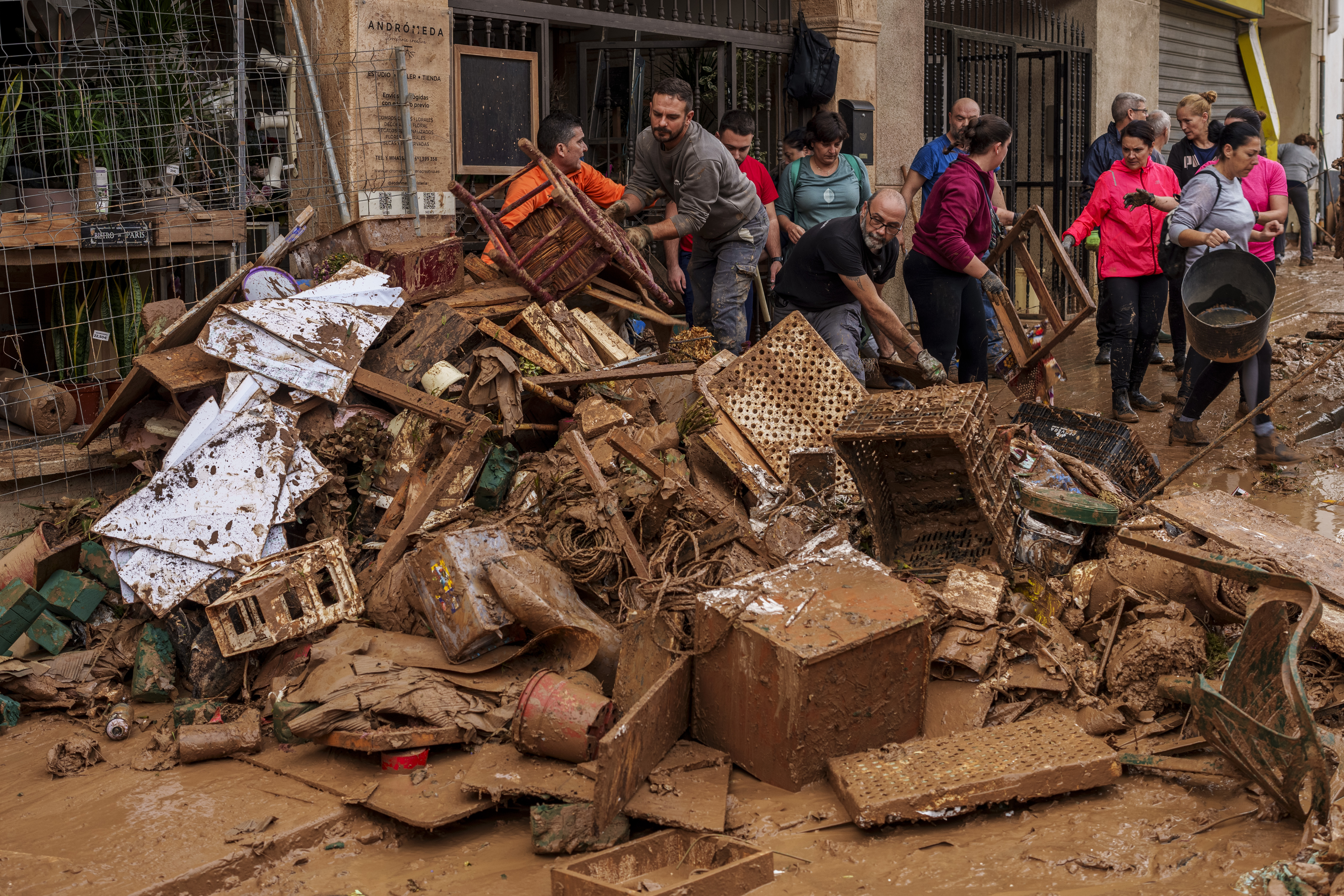 People clean mud from a shop affected by floods in Chiva, Spain, Friday, Nov. 1, 2024.<br />(Manu Fernandez / AP Photo)