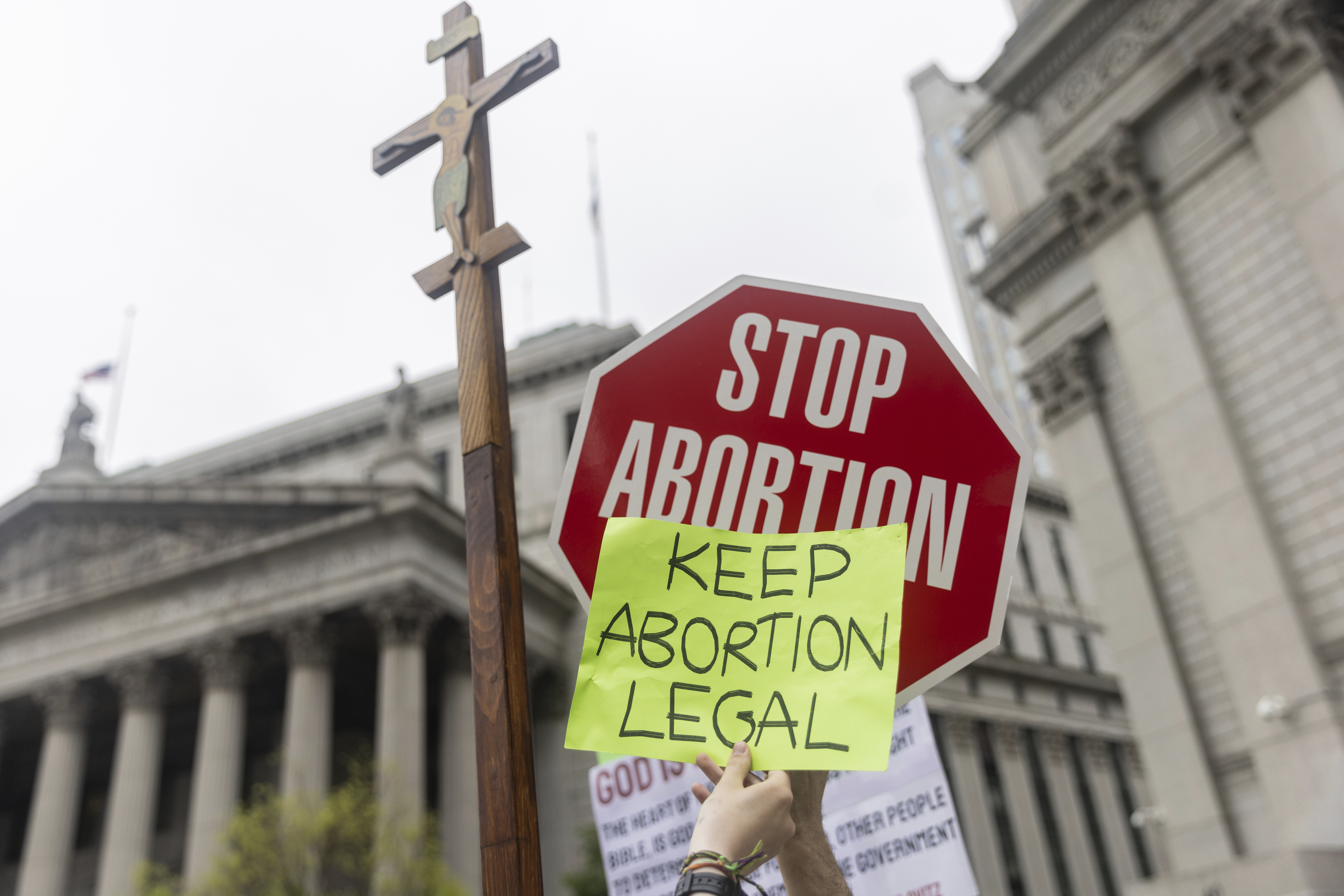 Protesters hold competing signs about abortion laws.<br />(Jeenah Moon / AP Photo)