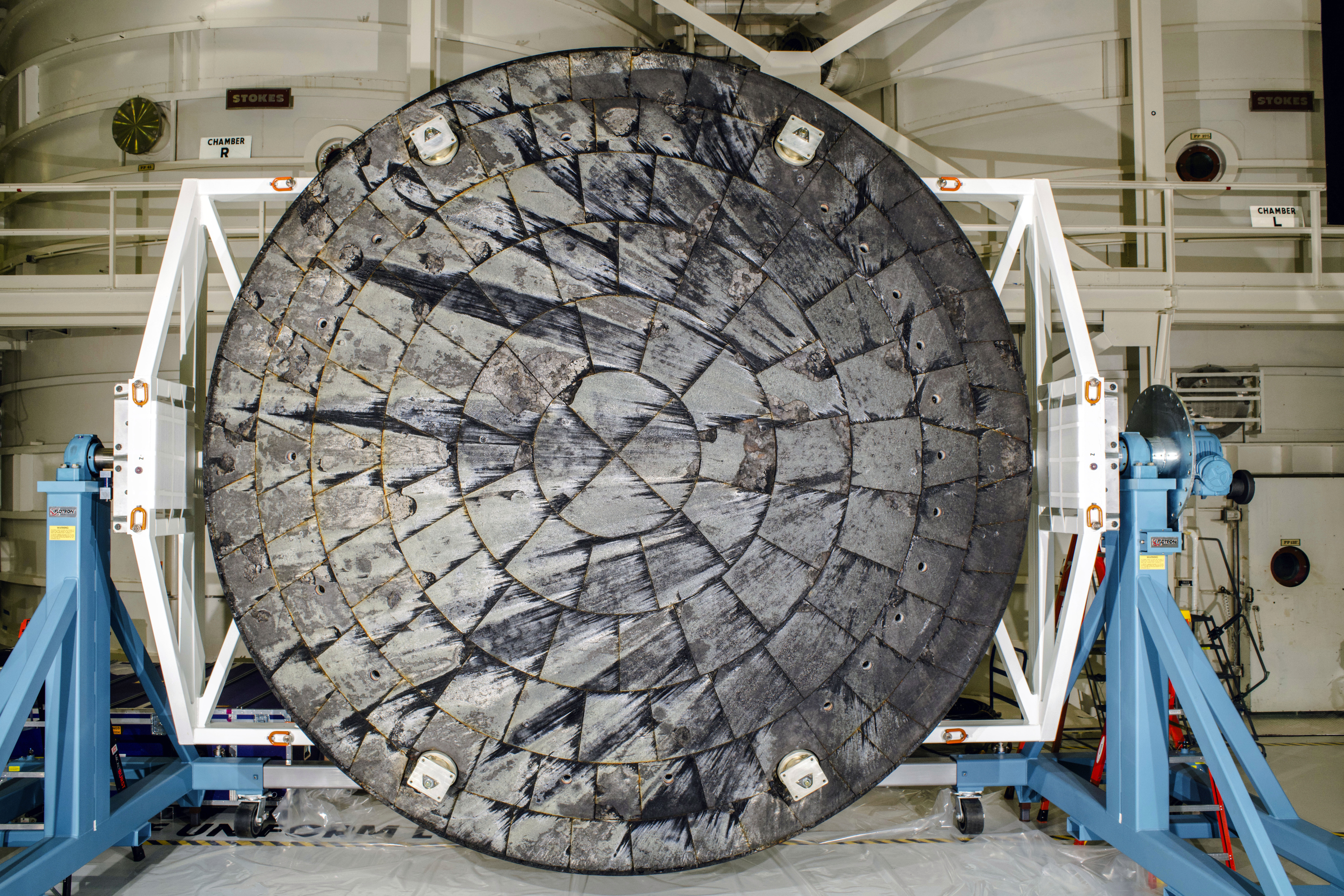 This Feb. 3, 2024 image provided by NASA shows the Orion spacecraft heat shield following the Artemis I test flight after it was was removed from the crew module inside the Operations and Checkout Building and rotated for inspection at the Kennedy Space Center in Cap Canaveral, Fla.<br />(NASA via AP)