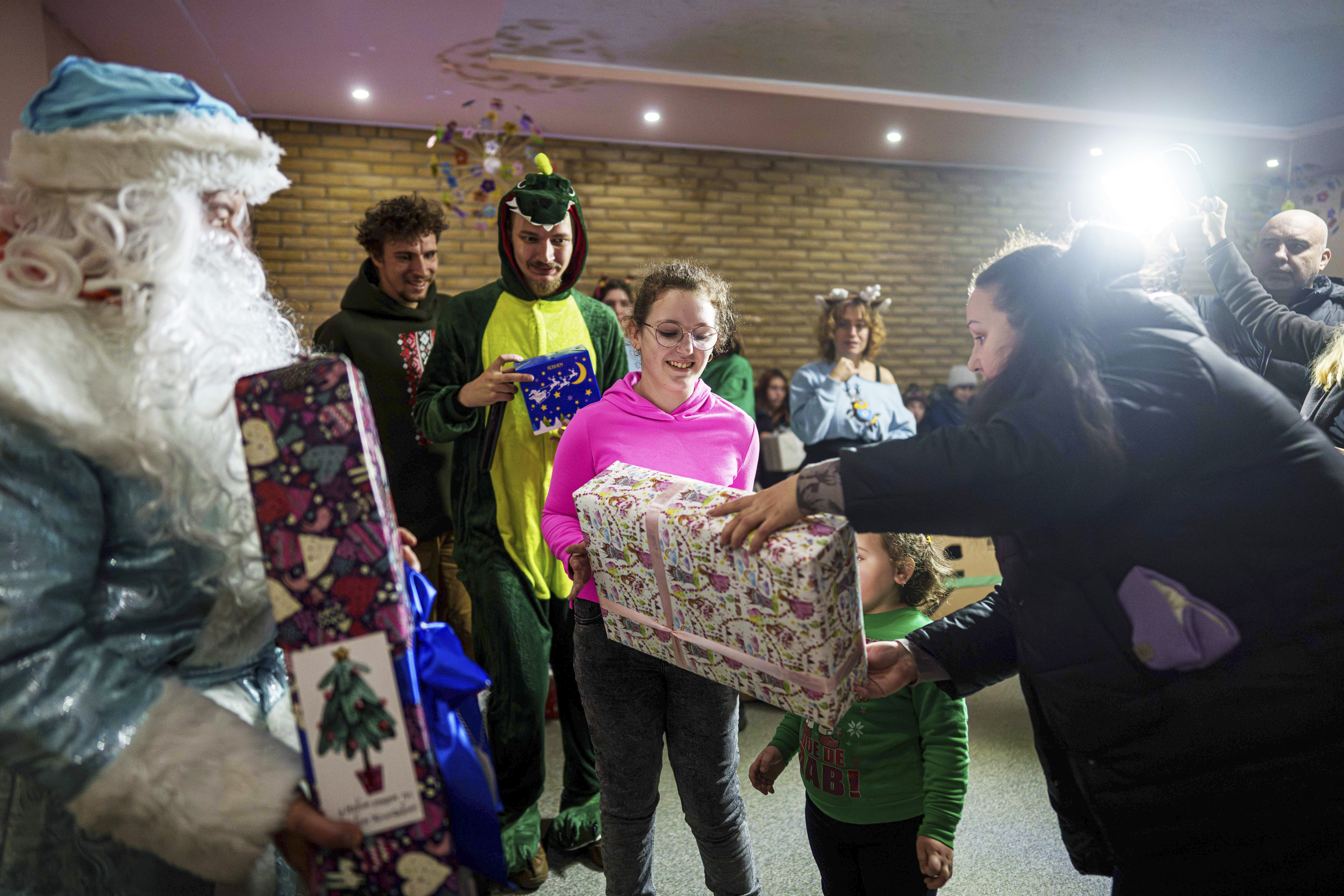 Children receive presents from volunteers of the NGO Ukrainian Frontiers during celebrations of St. Nicholas Day in Izium, Ukraine, Dec. 6, 2024.<br />(Evgeniy Maloletka / AP Photo)