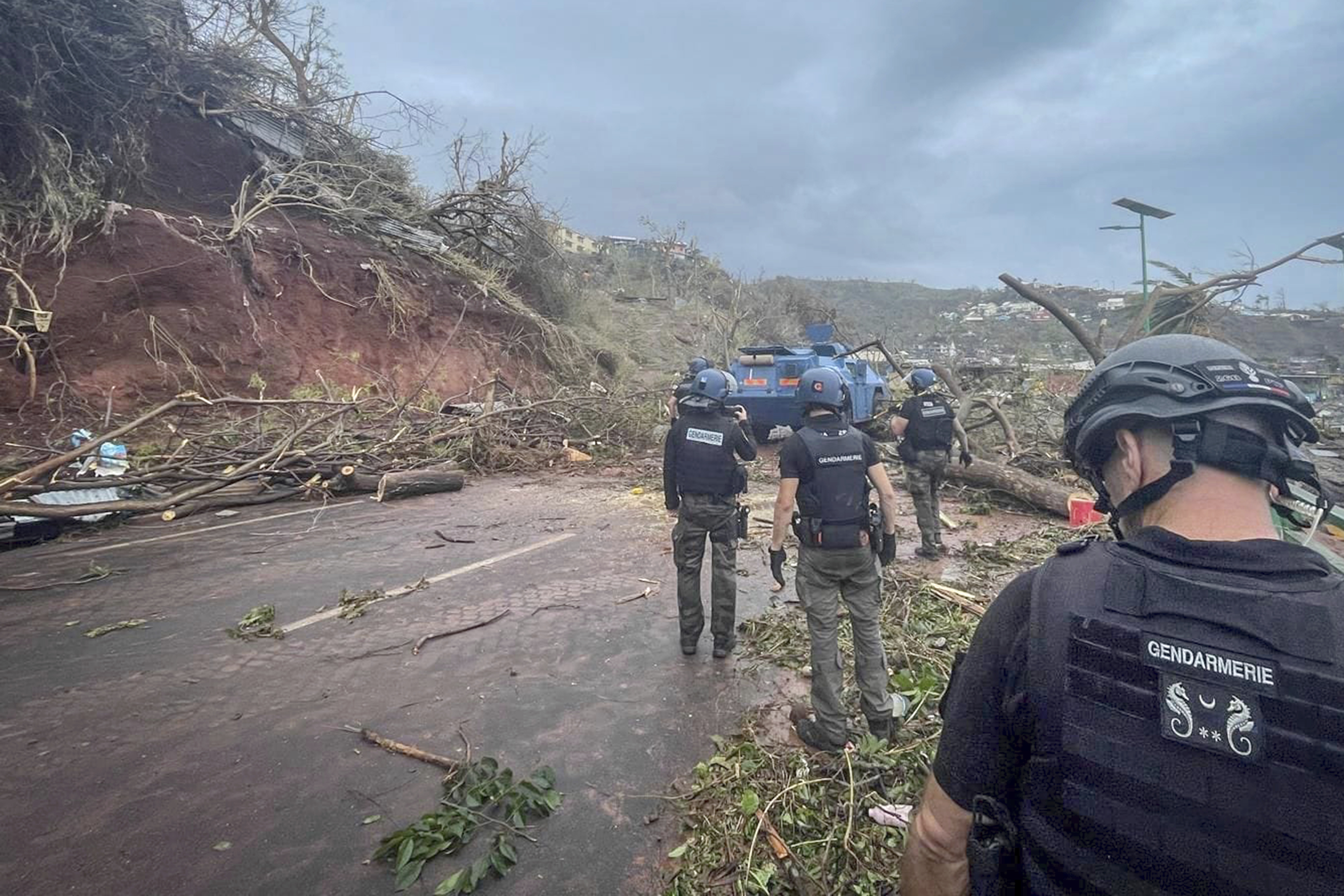 This photo provided Monday, Dec. 16, 2024 by the Gendarmerie Nationale shows Gendarmes clearing a road, Sunday, Dec. 15, 2024 in Mayotte as France rushed rescue teams and supplies to its largely poor overseas department in the Indian Ocean that has suffered widespread destruction.<br /> (Gendarmerie Nationale via AP)