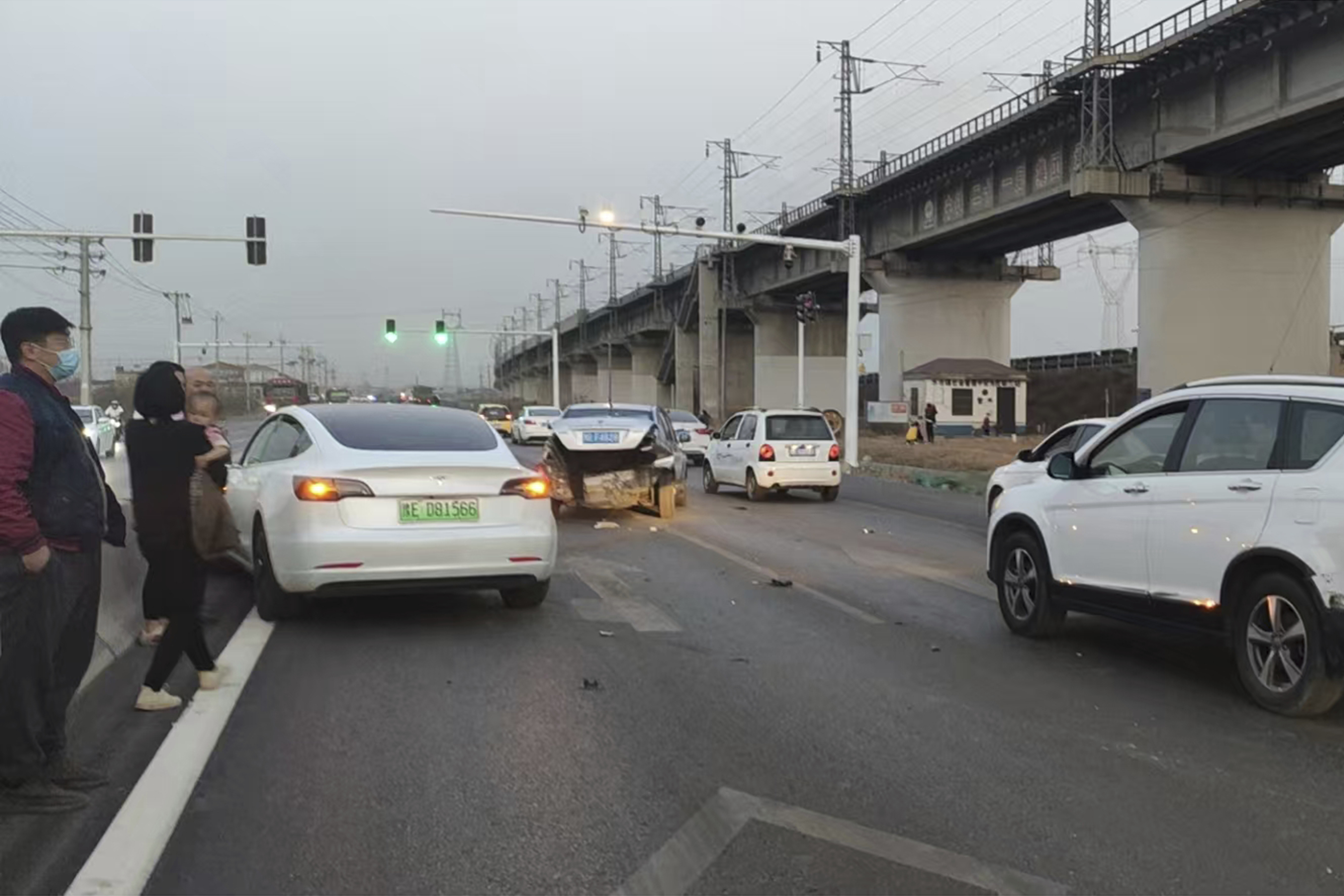 This photo provided by Zhang Yazhou shows her damaged Tesla Model 3 (left) which her father was driving when it hit two other cars before crashing to a halt against a concrete barrier in Anyang, a city in central China’s Henan province, on Feb. 21, 2021. Zhang was in the passenger seat. Her mother and her one-year-old niece were at the back.<br />(Zhang Yazhou via AP)