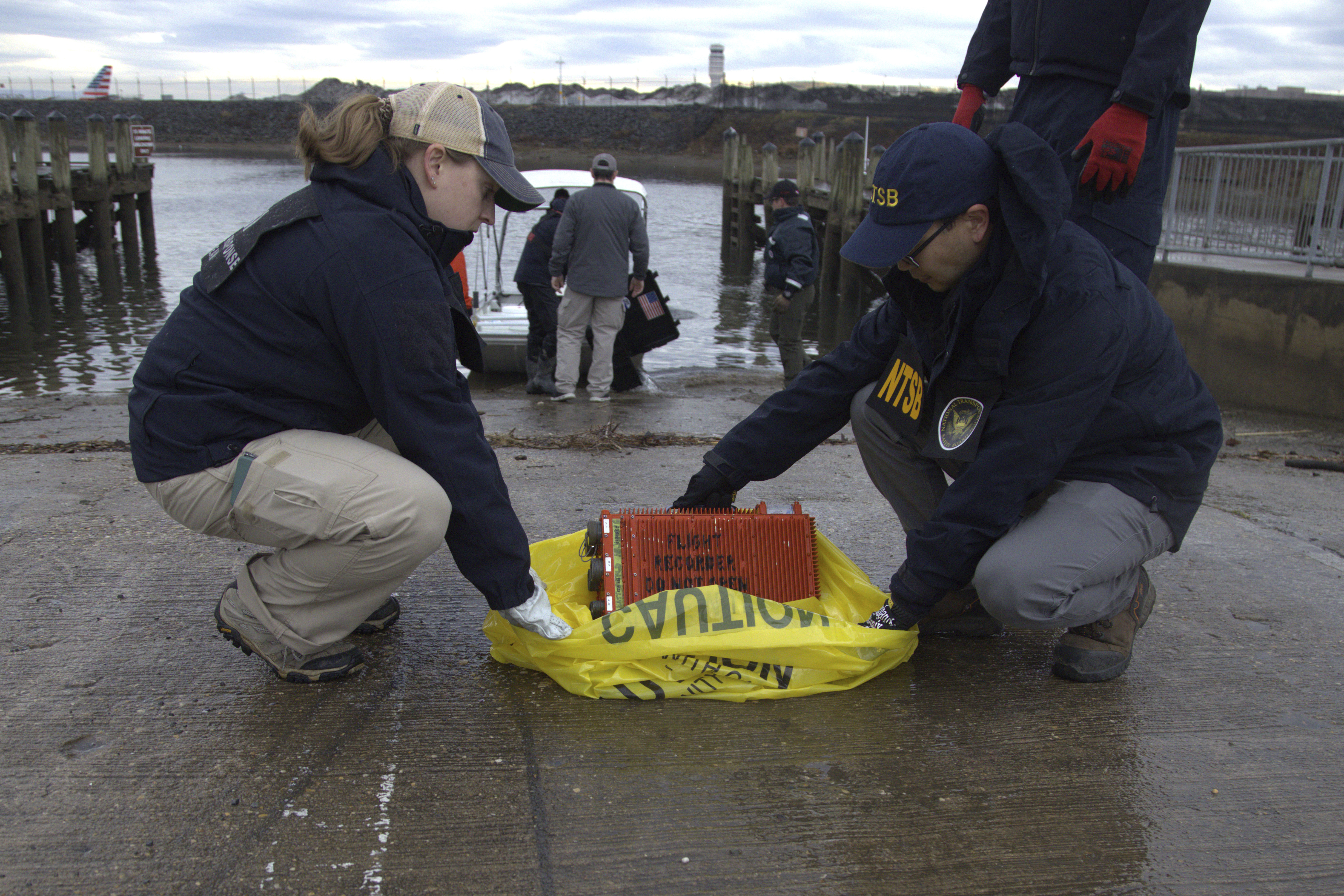 NTSB investigators examine a flight data recorder recovered from the wreckage of a mid-air collision between an Army Black Hawk helicopter and an American Airlines jet Wednesday night, Jan. 29, 2025, near Ronald Reagan Washington National Airport in Arlington, Va.<br />(NTSB via AP)