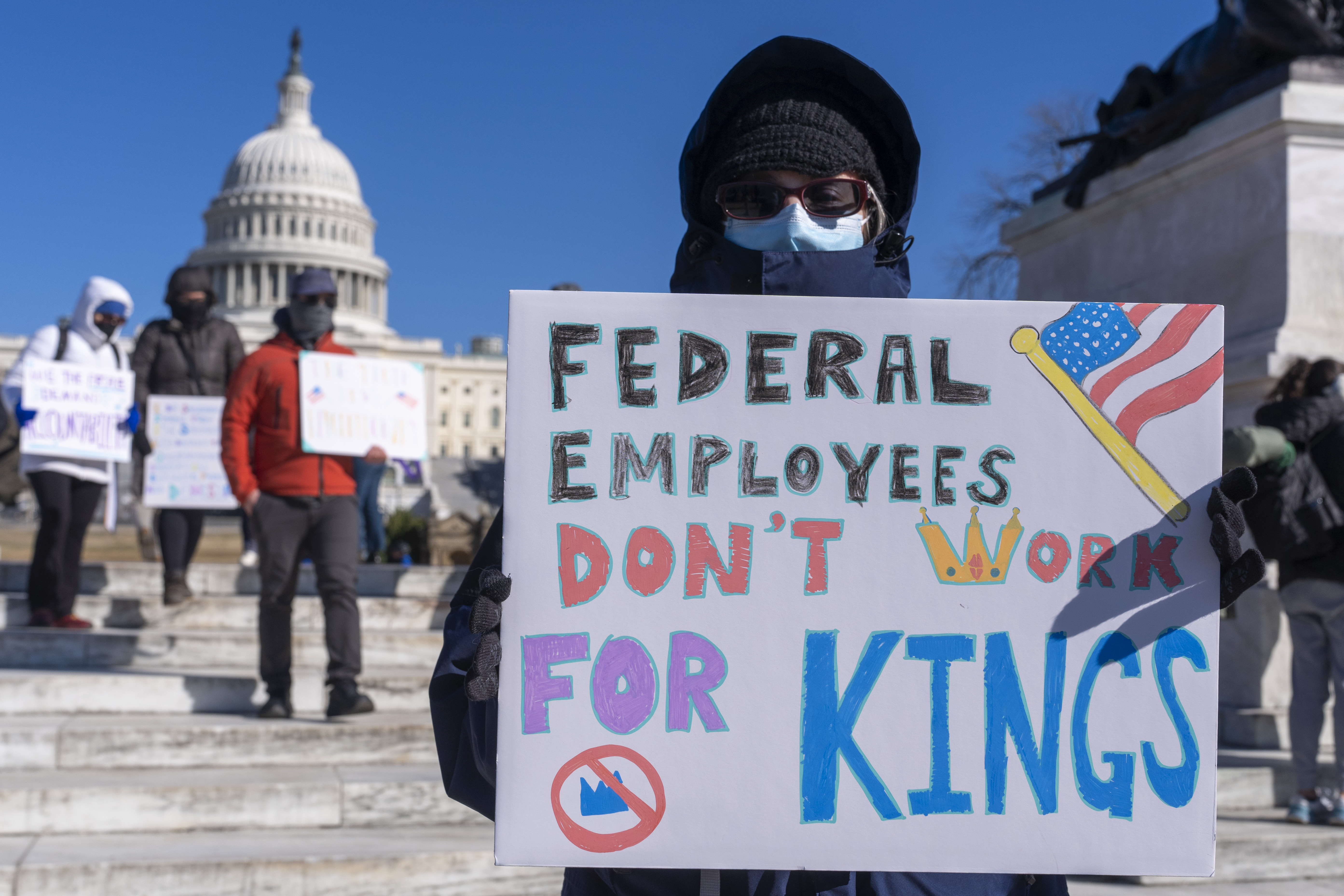 A federal employee, who asked not to use their name for fears over losing their job, protests with a sign saying &quot;Federal Employees Don&#039;t Work for Kings&quot; during the &quot;No Kings Day&quot; protest on Presidents Day in Washington, in support of federal workers and against recent actions by President Donald Trump and Elon Musk, Monday, Feb. 17, 2025, by the Capitol in Washington.<br />(Jacquelyn Martin / AP Photo)