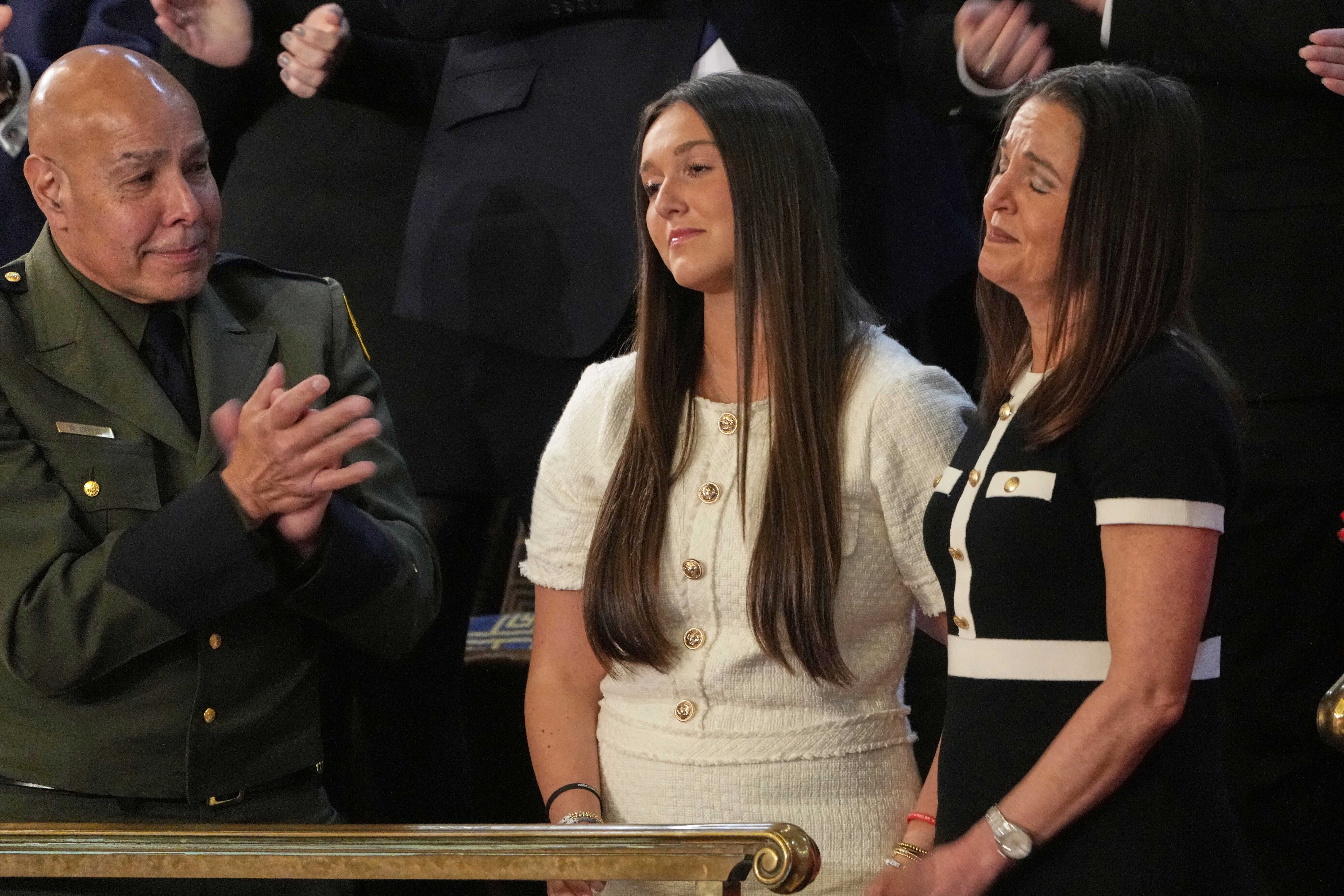 Roberto Ortiz of Weslaco, Texas, applauds Allyson Phillips, mother of Laken Riley, and sister Lauren Phillips of Woodstock, Ga., as President Donald Trump addresses a joint session of Congress in the House chamber at the U.S. Capitol in Washington, Tuesday, March 4, 2025.<br />(Julia Demaree Nikhinson / AP Photo)