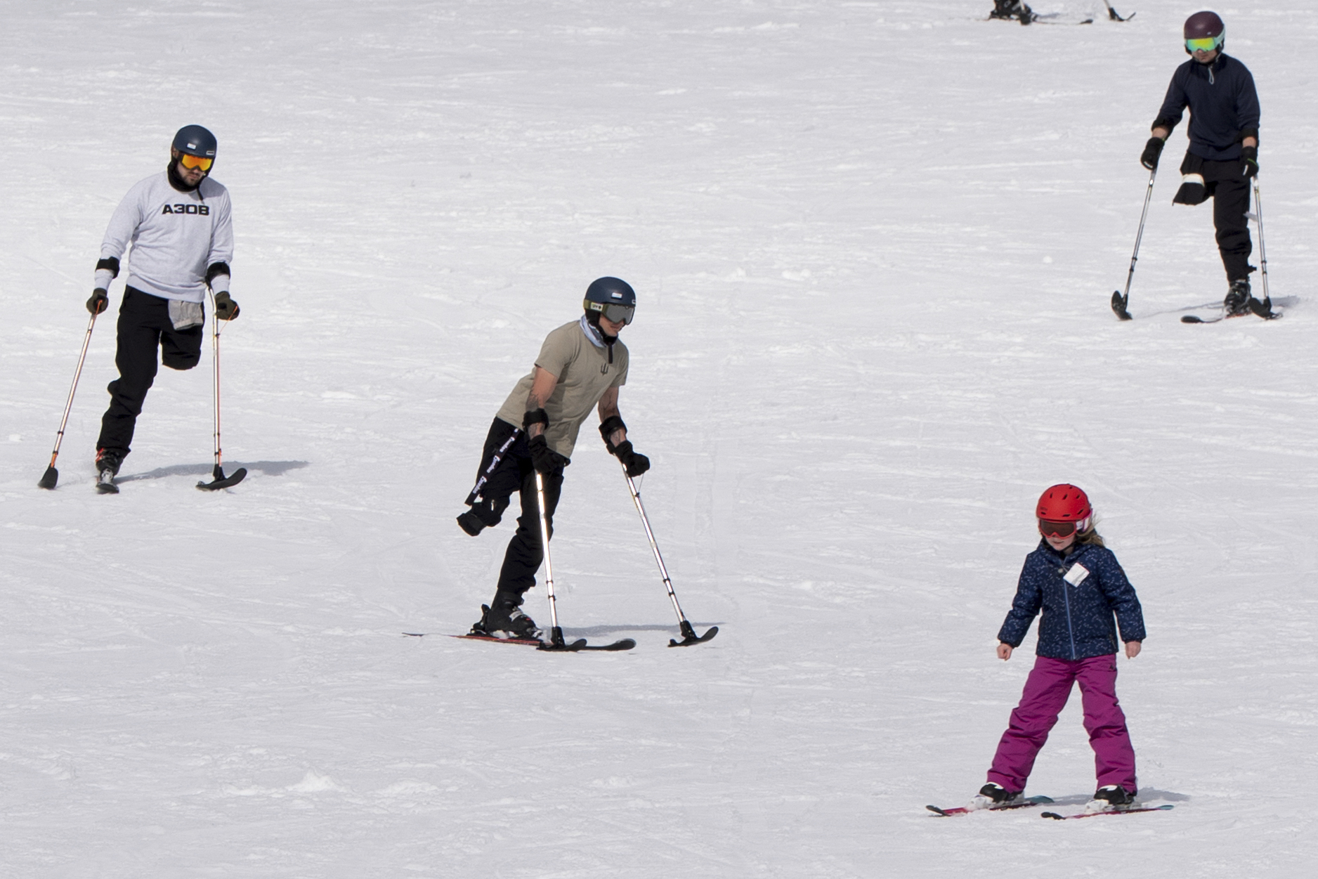 Ukrainian veterans Denys Kryvodubski (left) Stanislav Povkhan (center) and Mikhailo Danylo (top right) ski down a slope to warm up during a lesson with Oregon Adaptive Sports on the three track skiing method at Hoodoo Ski Area in central Oregon on Thursday, March 6, 2025.<br />(Jenny Kane / AP Photo)