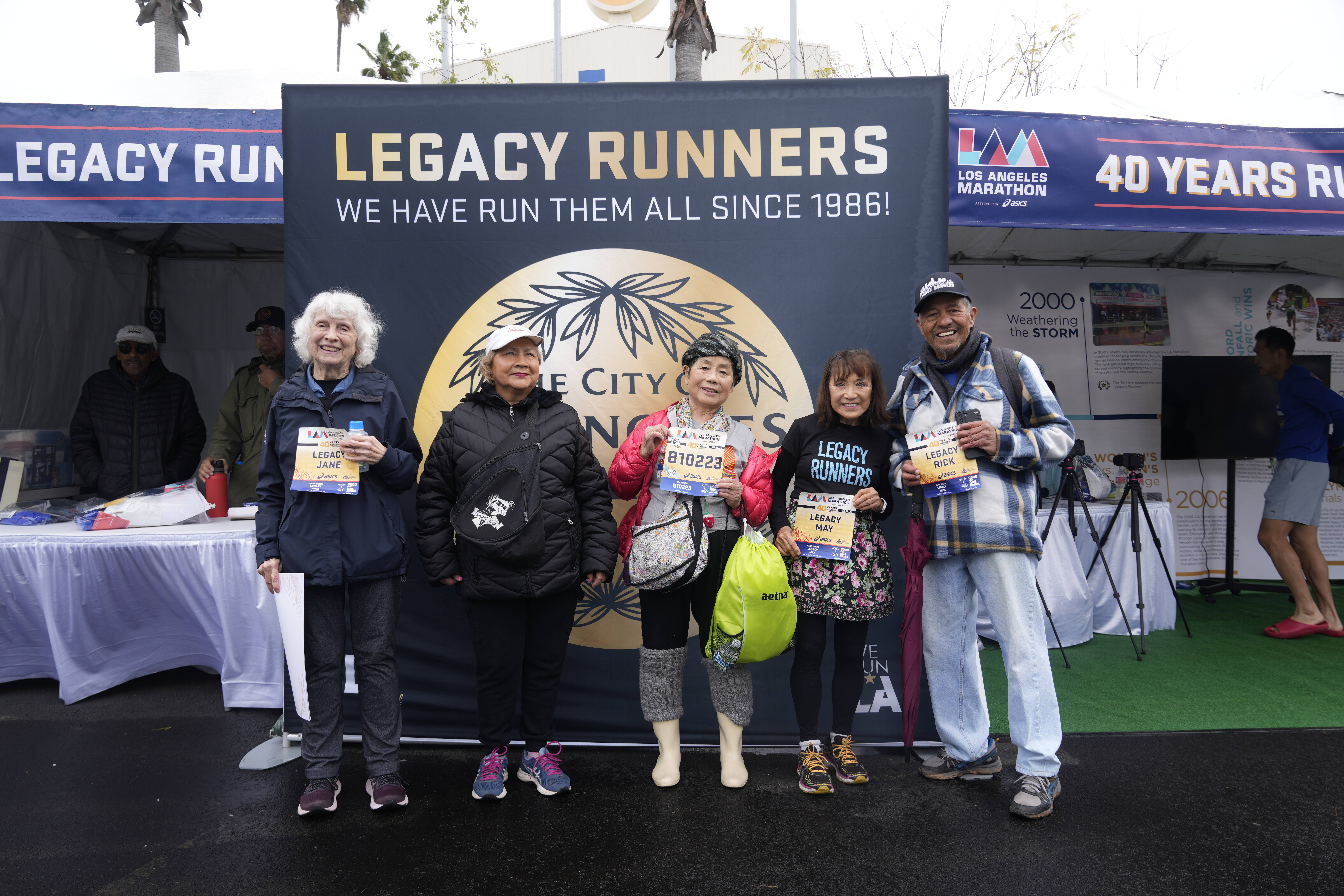 Masako Higuchi, 83 (center) and May DuBois (second from right) take photos with fellow runners ahead of the Los Angeles Marathon at the Lifestyle Expo at Dodger Stadium, Friday, March 14, 2025 in Los Angeles.<br />(Damian Dovarganes / AP Photo)