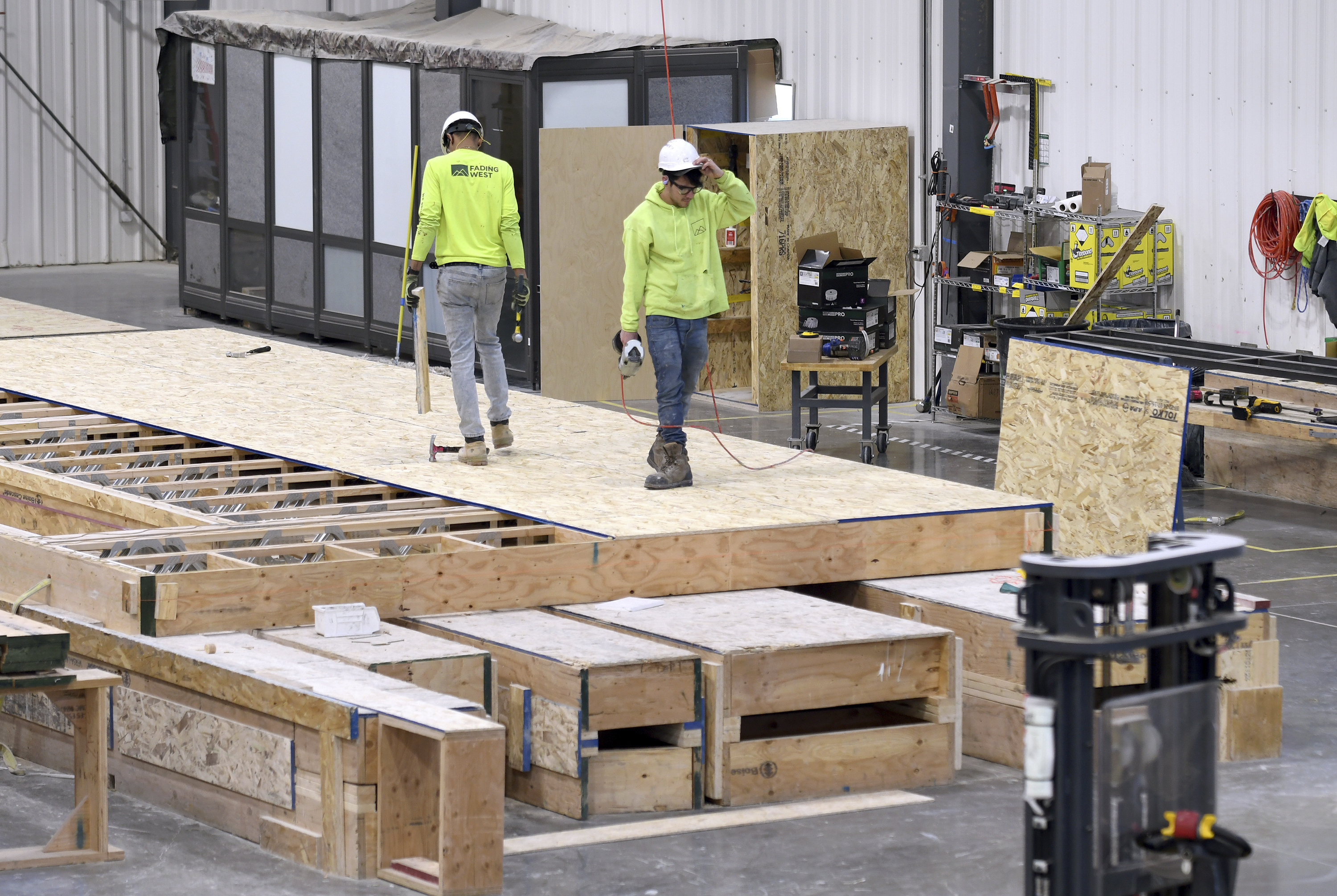 Workers construct the flooring of a modular home at the Fading West factory in Buena Vista, Colo., on Feb. 19, 2025.<br />(Thomas Peipert / AP Photo)