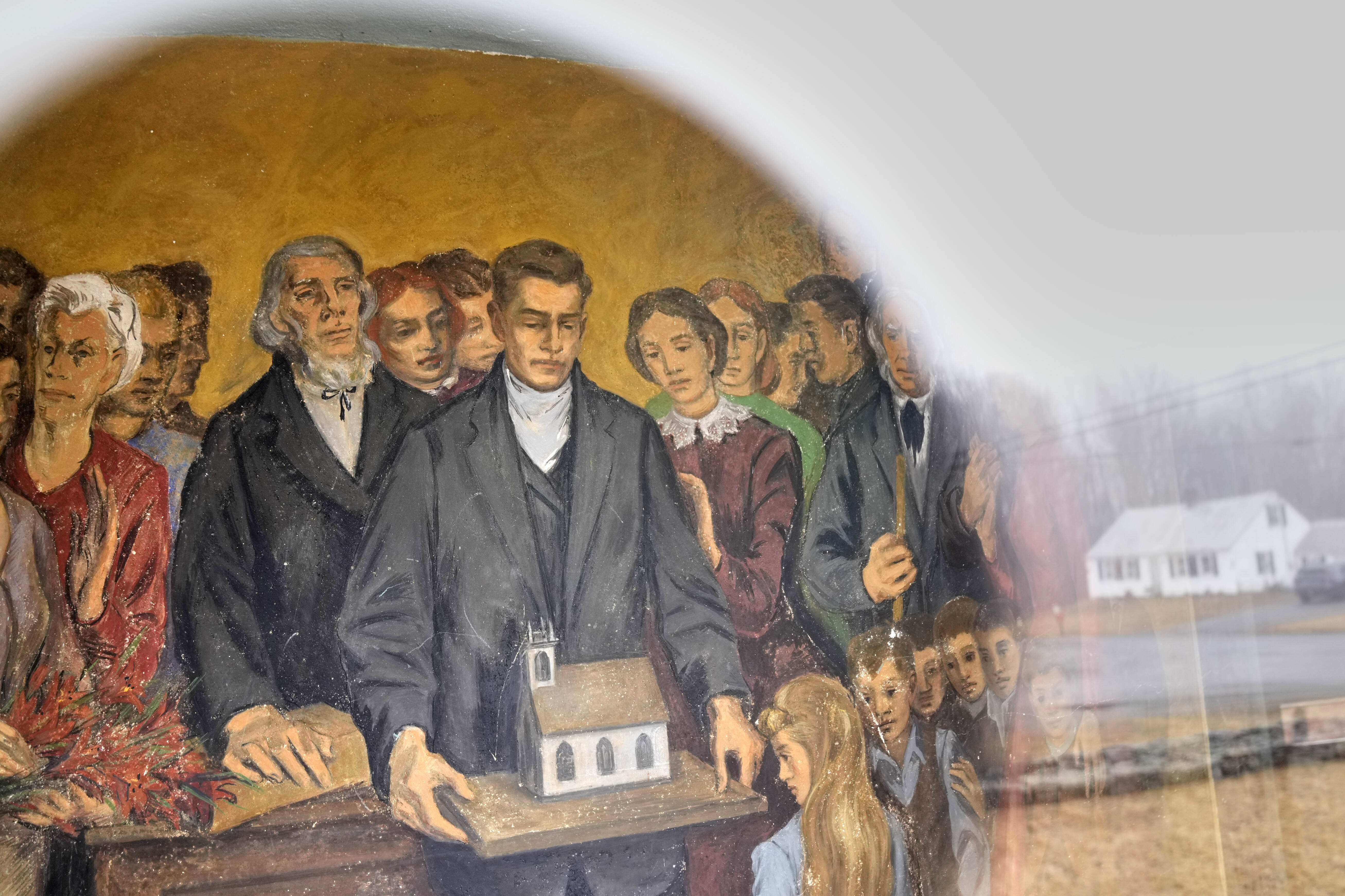 A fresco depicting community members with a model of South Solon Meeting House is seen through a window in the lobby of the building, Sunday, April 6, 2025, in Solon, Maine.<br />(Robert F. Bukaty / AP Photo)
